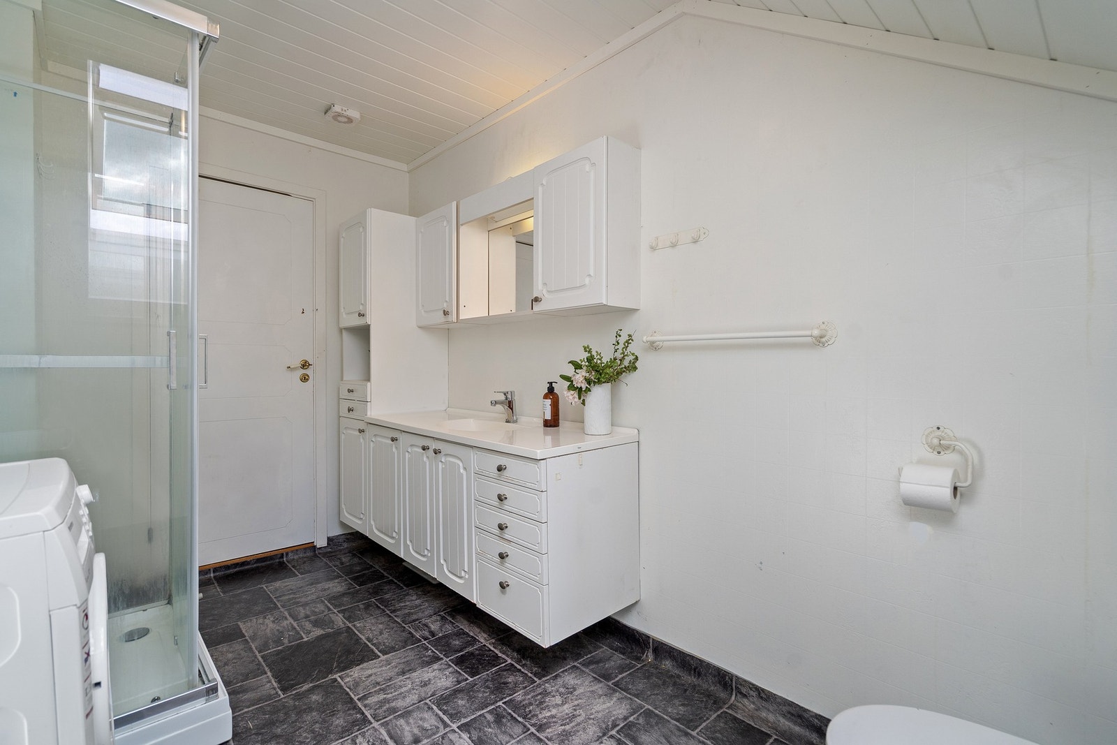 Baderommet i denne etasjen har dusj, opplegg til vaskemaskin, servantinnredning og wc Galleribilde