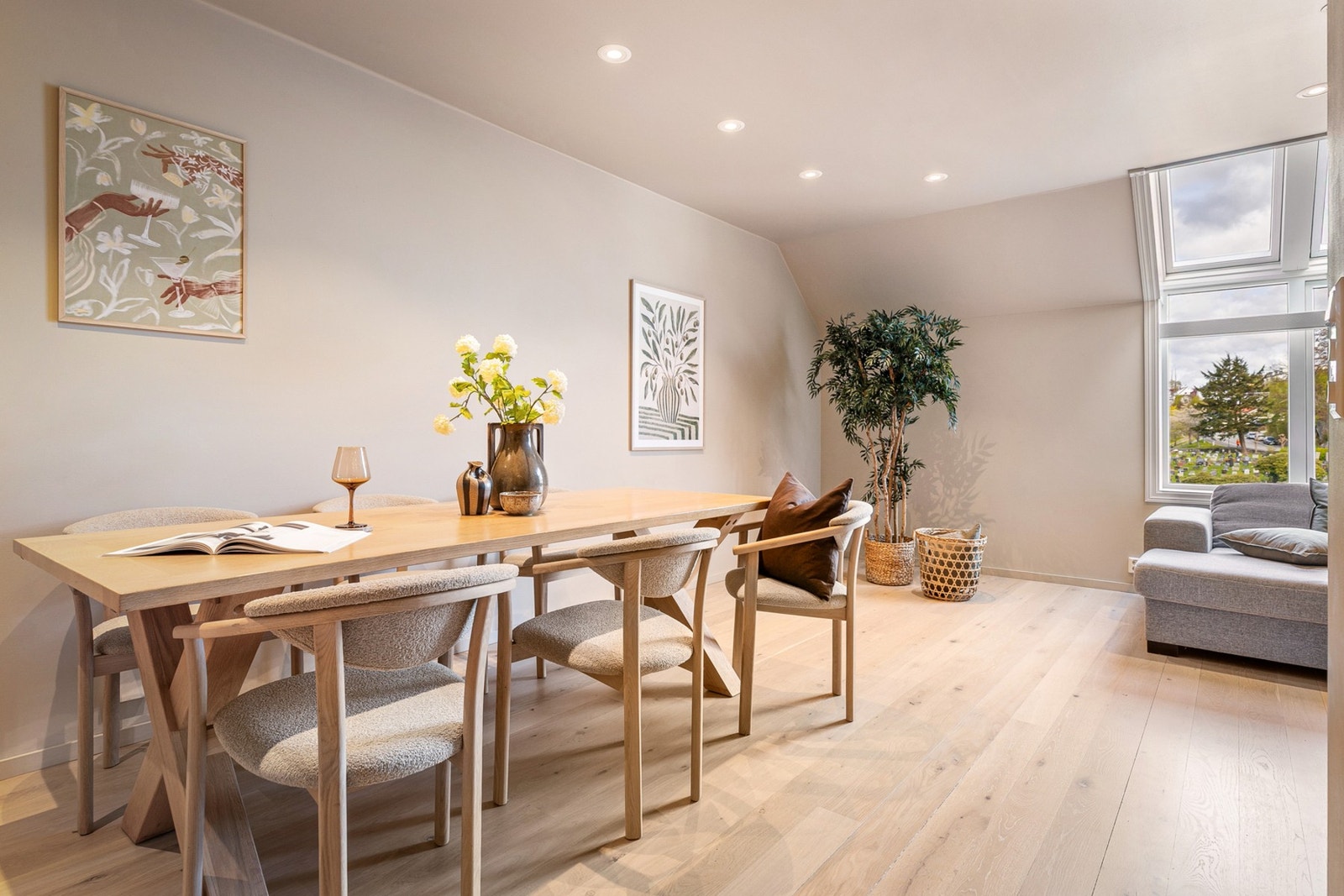Den åpne planløsningen gir god plass til både sofagruppe og spisebord, og rommet fremstår som et naturlig samlingspunkt i boligen. Galleribilde