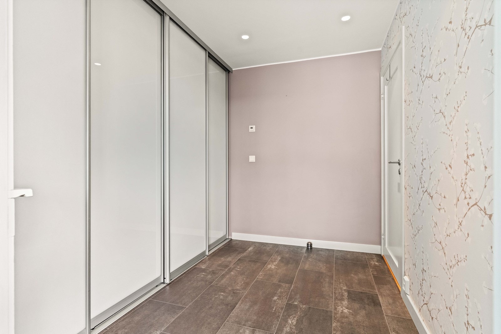 Entré med varmekabler i gulv. God plass til sko og yttertøy i en praktisk skyvedørsgarderobe. Galleribilde