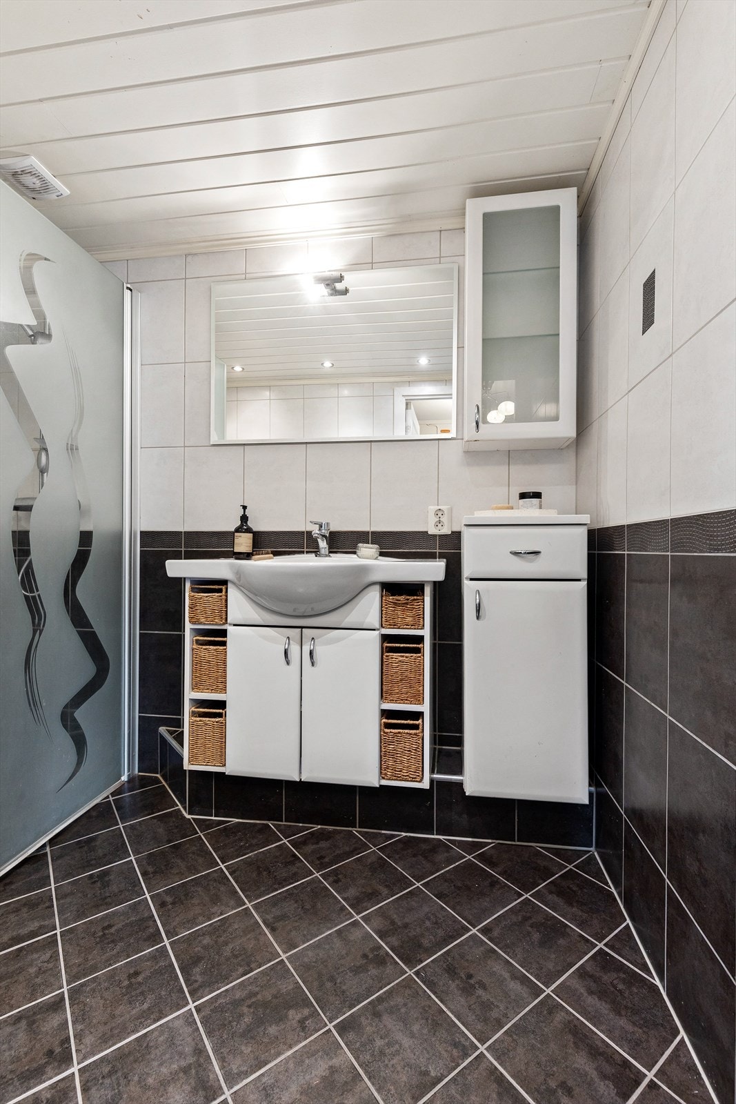 Badet er utstyrt med elektrisk gulvvarme, servantinnredning og downlights i taket. Galleribilde