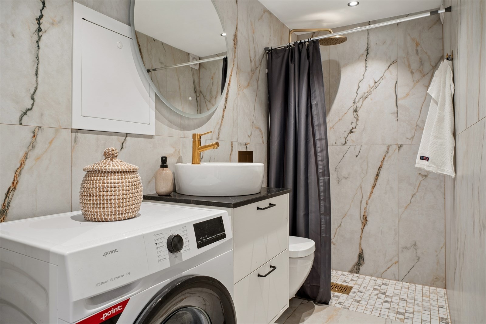 Badet i hybelen er fra 2025, med fliser, gulvvarme og opplegg for vaskemaskin. Galleribilde