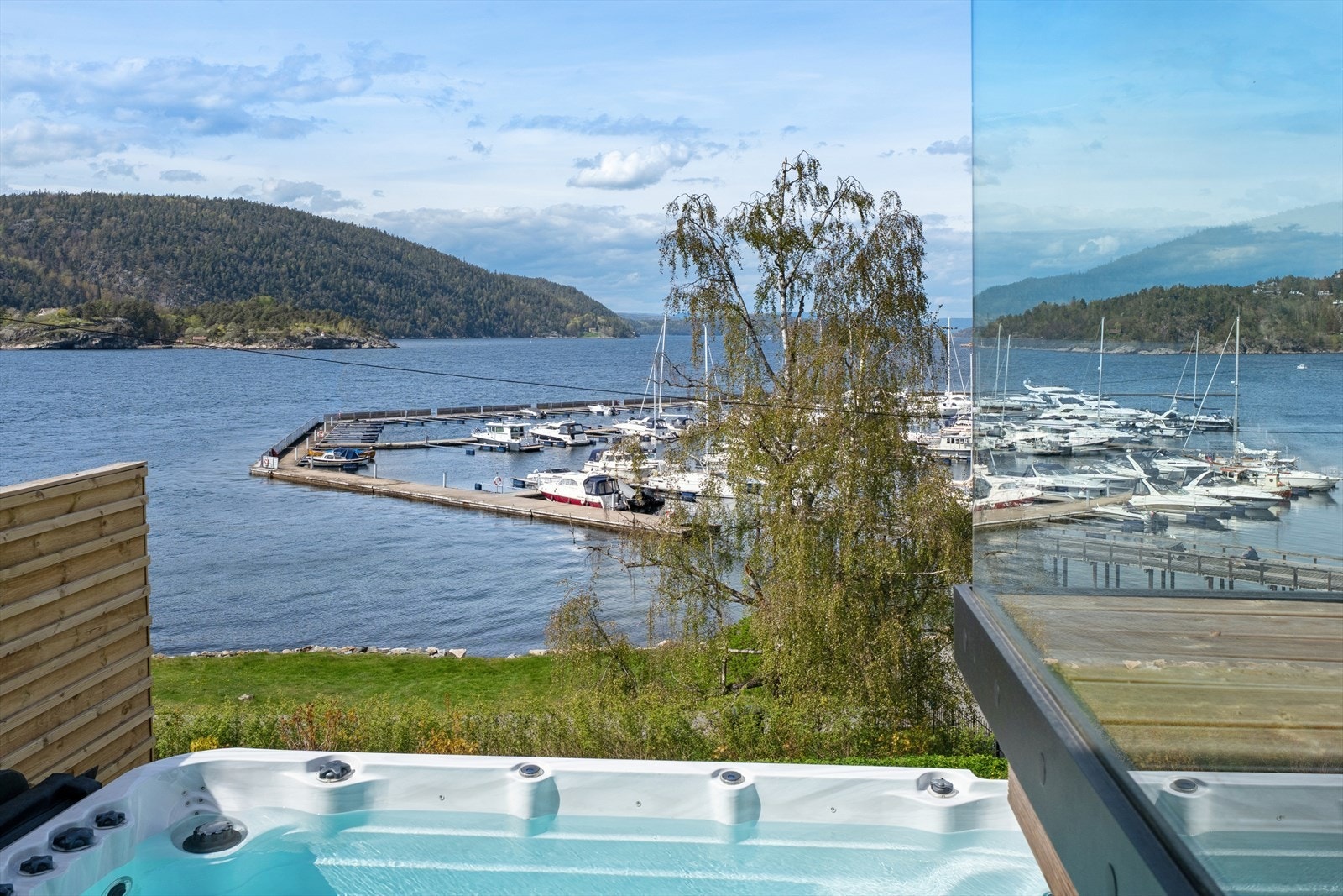 Jacuzzi elegant integrert i tilknytning til treplatting og terrasse - et privat og innbydende uterom med høy komfort, perfekt for avslapning året rundt. Galleribilde