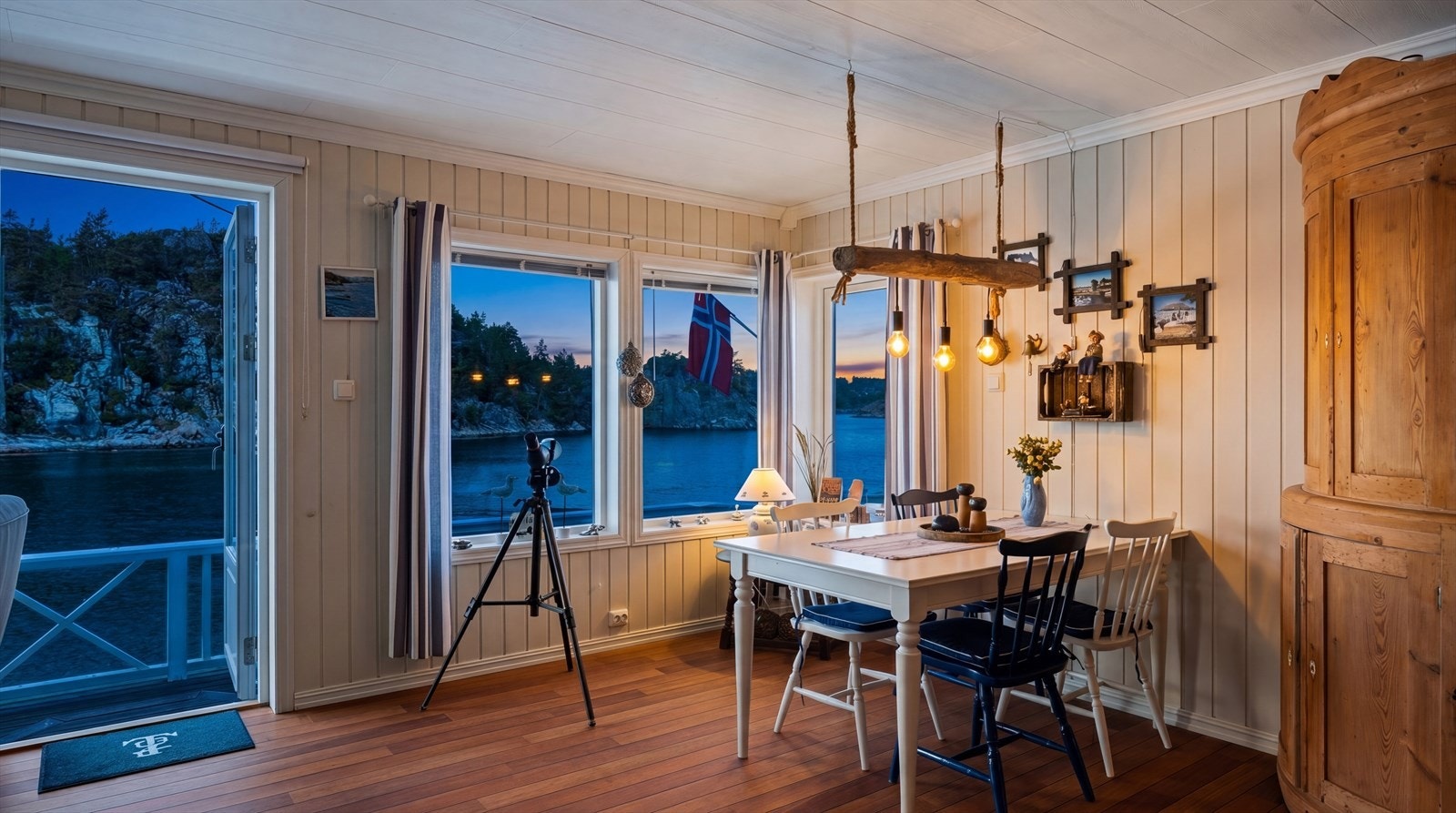 Når mørket senker seg, skapes en stemningsfull atmosfære med utsikt mot vannet. Galleribilde