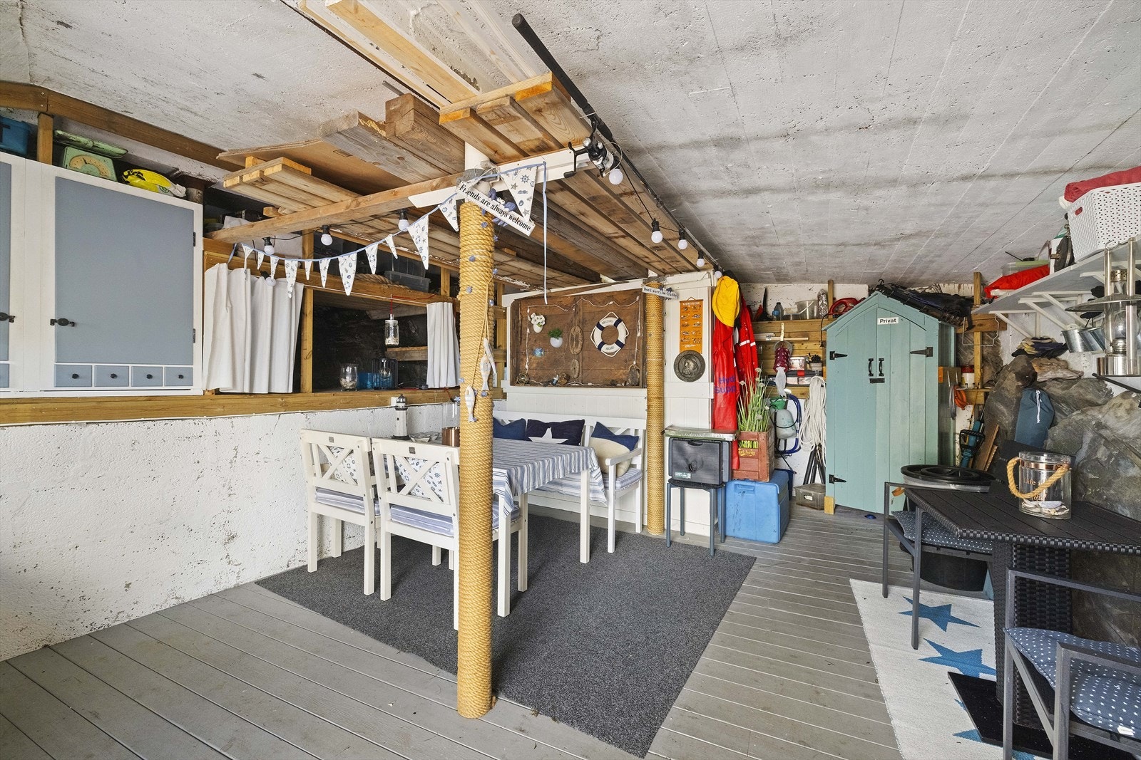 Naustet er innredet med plass til oppbevaring og en enkel sittegruppe under tak. Galleribilde
