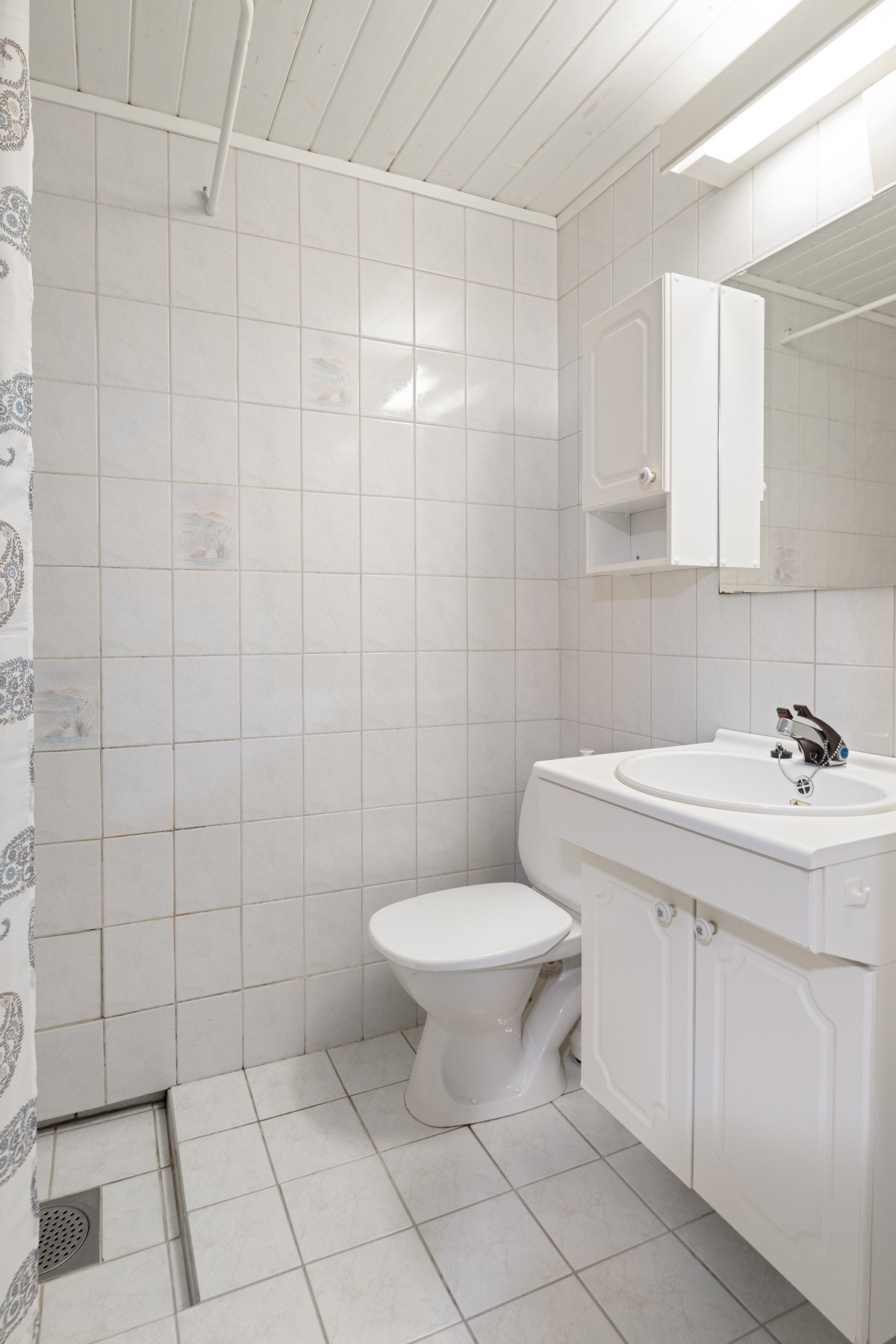 Bad i underetasjen har fliser på gulv og vegger. (Rommet er ikke omsøkt/bruksendret hos kommunen). Galleribilde