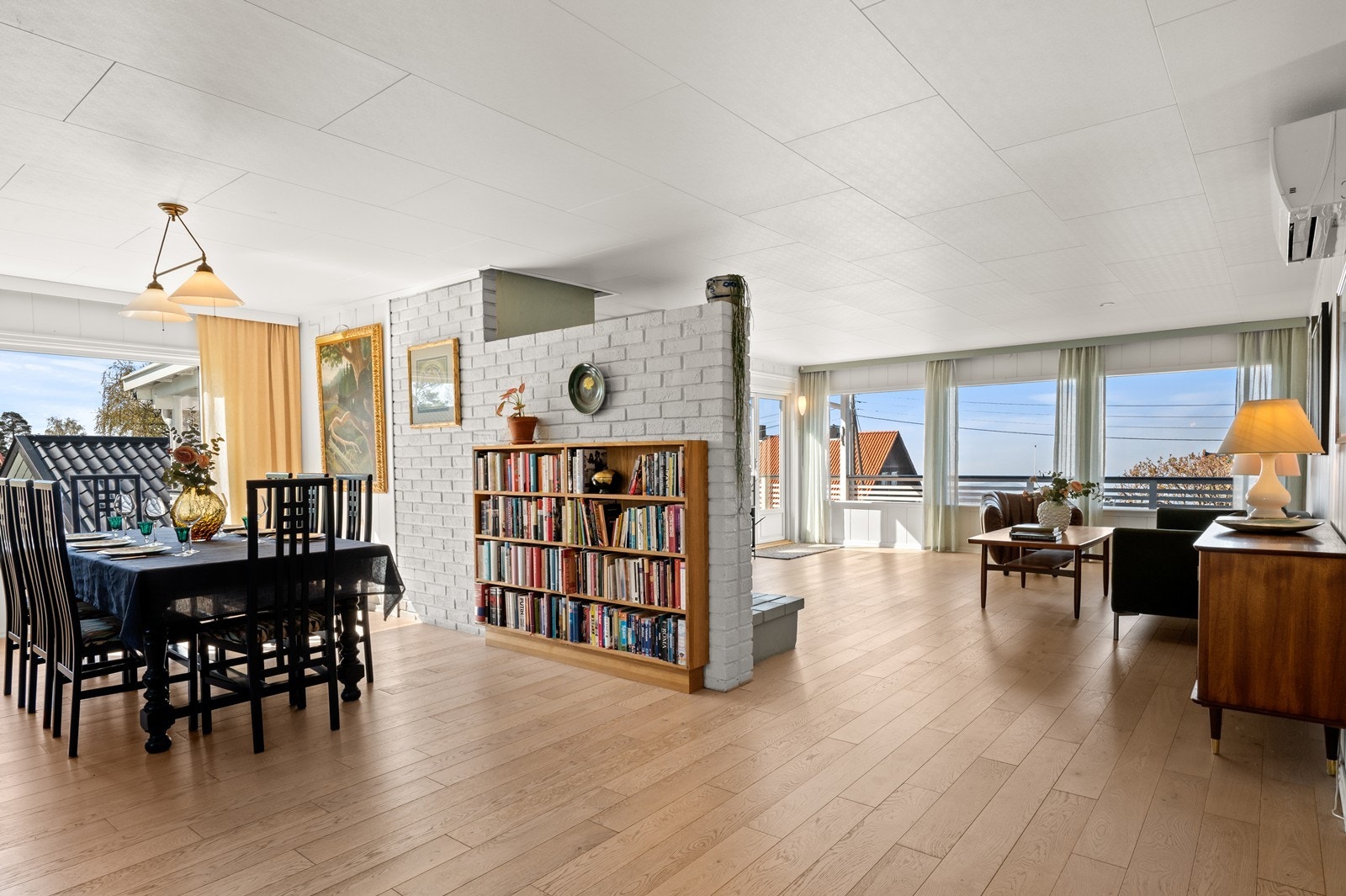 Stuen er todelt, med spisestue og salongdel på hver side av peisen Galleribilde