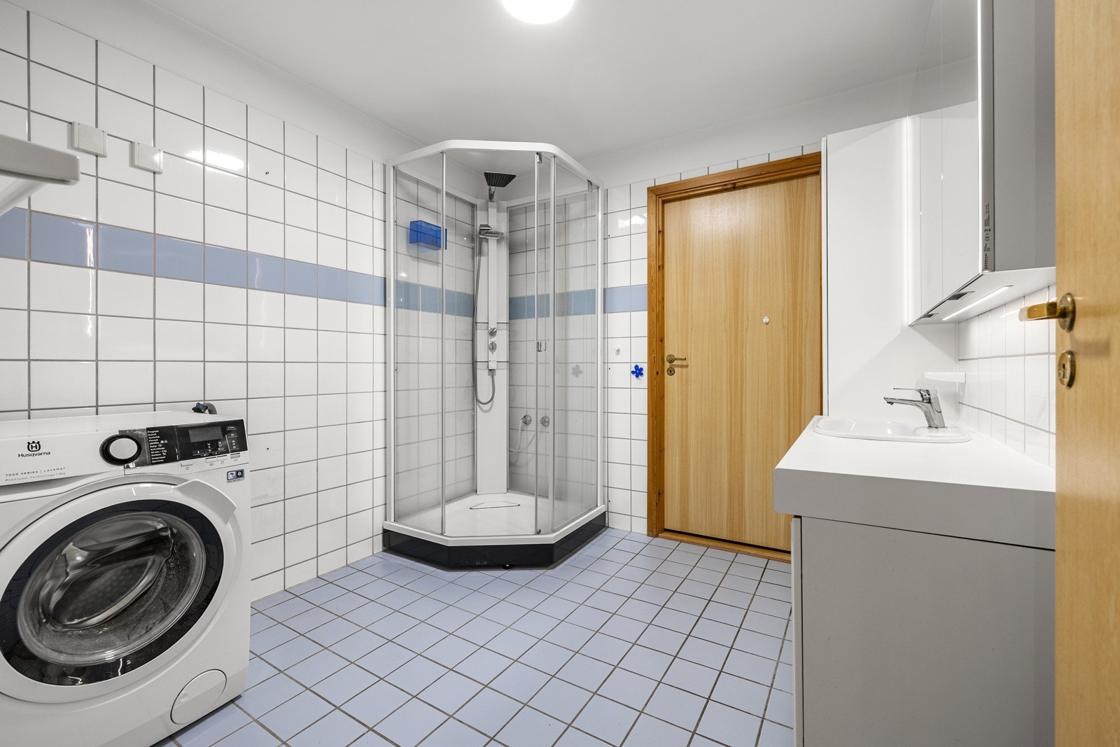 Badet har flislagt gulv med elektriske varmekabler og praktisk opplegg for vaskemaskin. Galleribilde