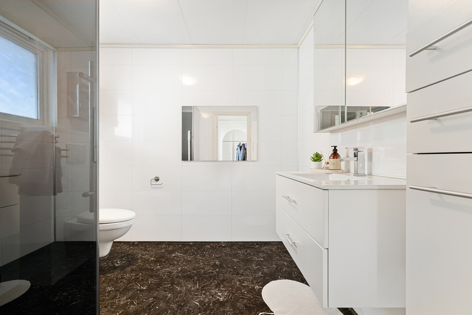 Badet i første etasje har gulvvarme, vegghengt toalett og godt med oppbevaring i seksjon og langskap. Galleribilde