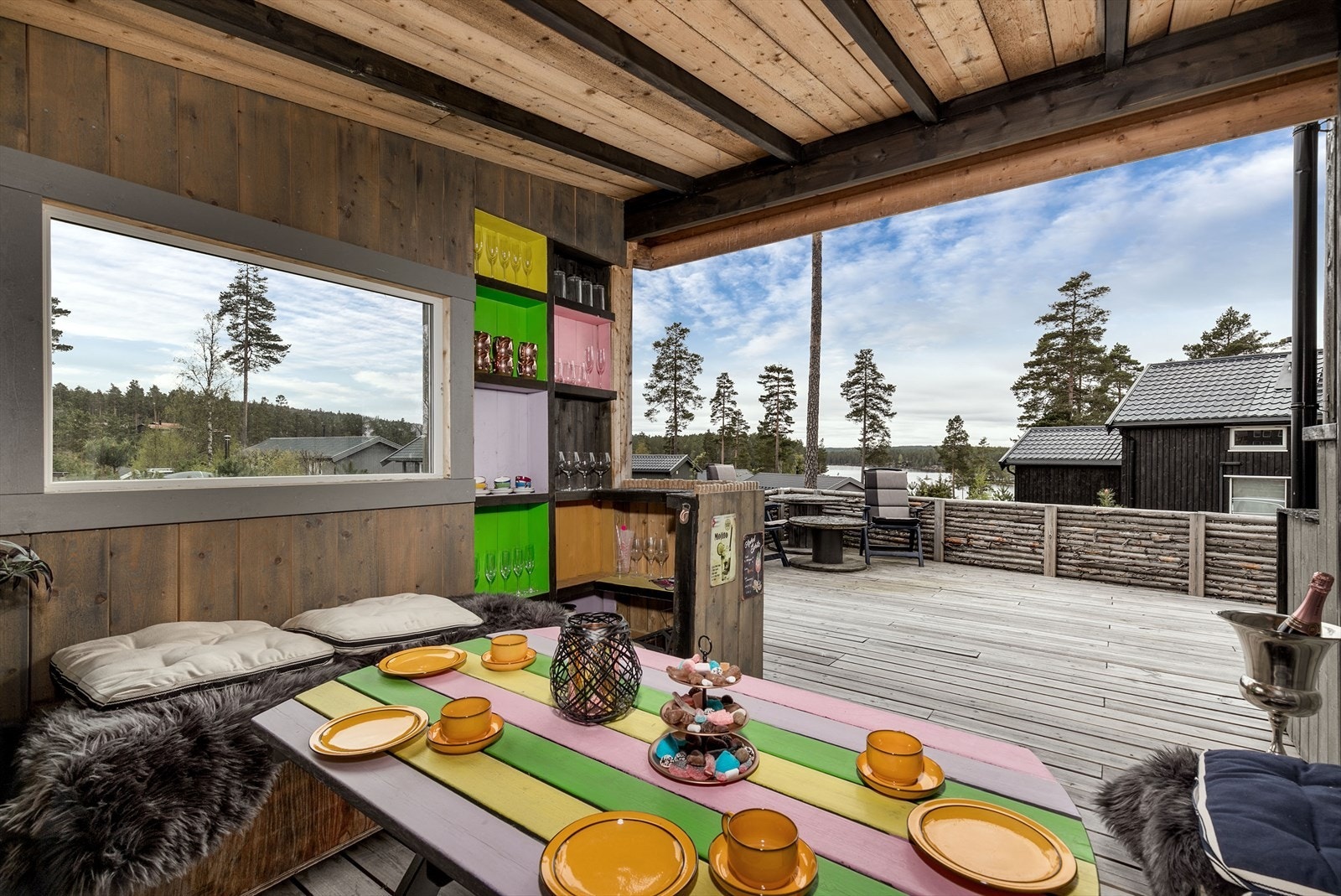 Terrassen har dekke og rekkverk i tre, og i tilbygget er det plassbygde sittebenker, bar og hyller. Galleribilde