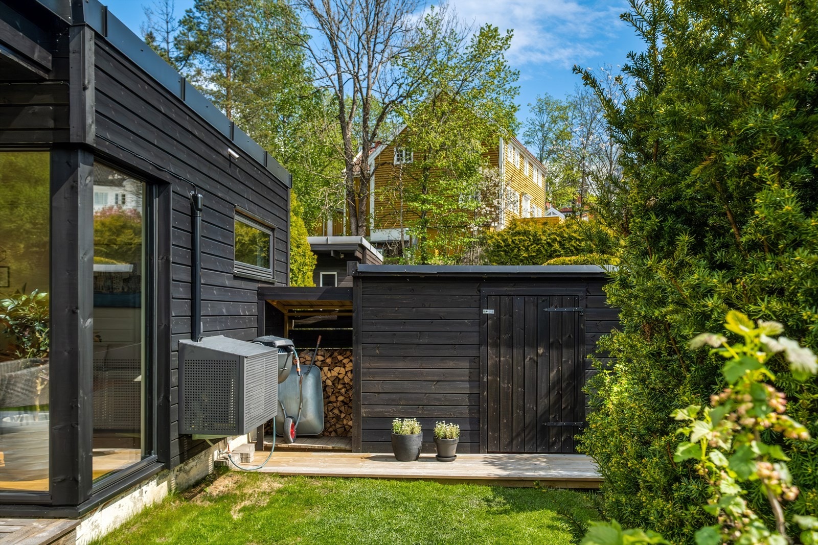 Ved siden av huset er det satt opp en smart utvendig bod til ved, utemøbler, hageutstyr, m.m Galleribilde
