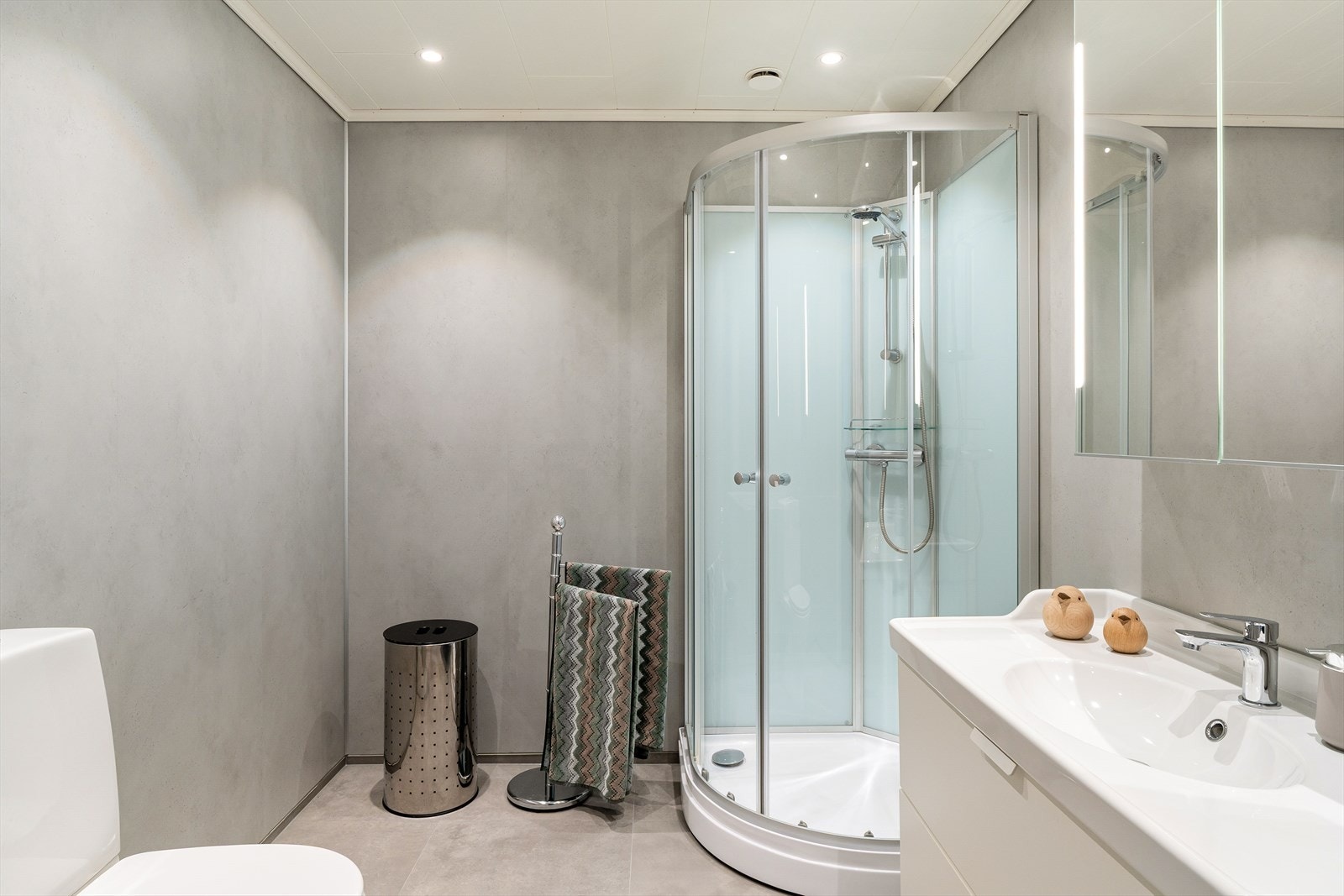 Badet i første etasje har baderomsplater på veggene, dusjkabinett og vegghengt toalett. Galleribilde