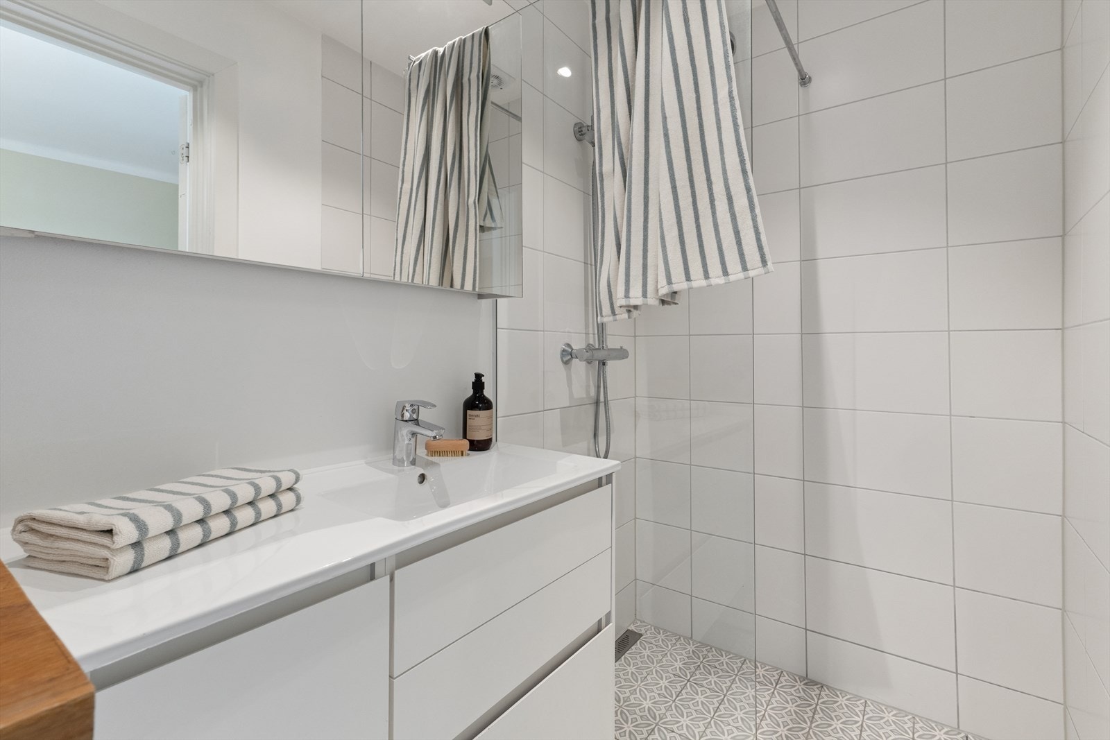 Badet er utstyrt med dusjnisje med glassvegger og stilren innredning. Galleribilde