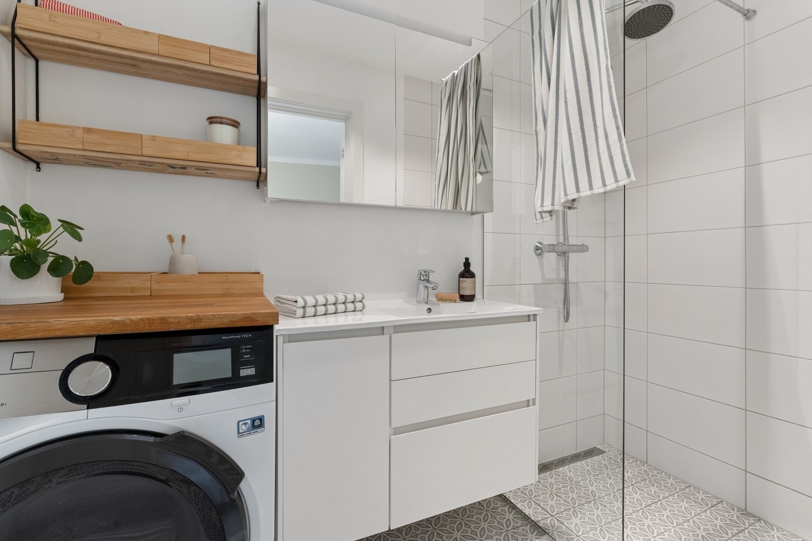 Badet fremstår som praktisk og godt utnyttet, med opplegg for vaskemaskin. Galleribilde
