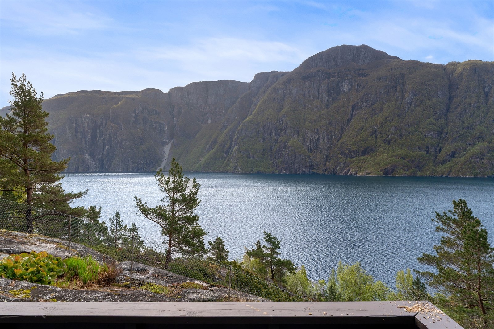 Utsikt over fjorden og de omkringliggende, bratte fjellsidene. Galleribilde
