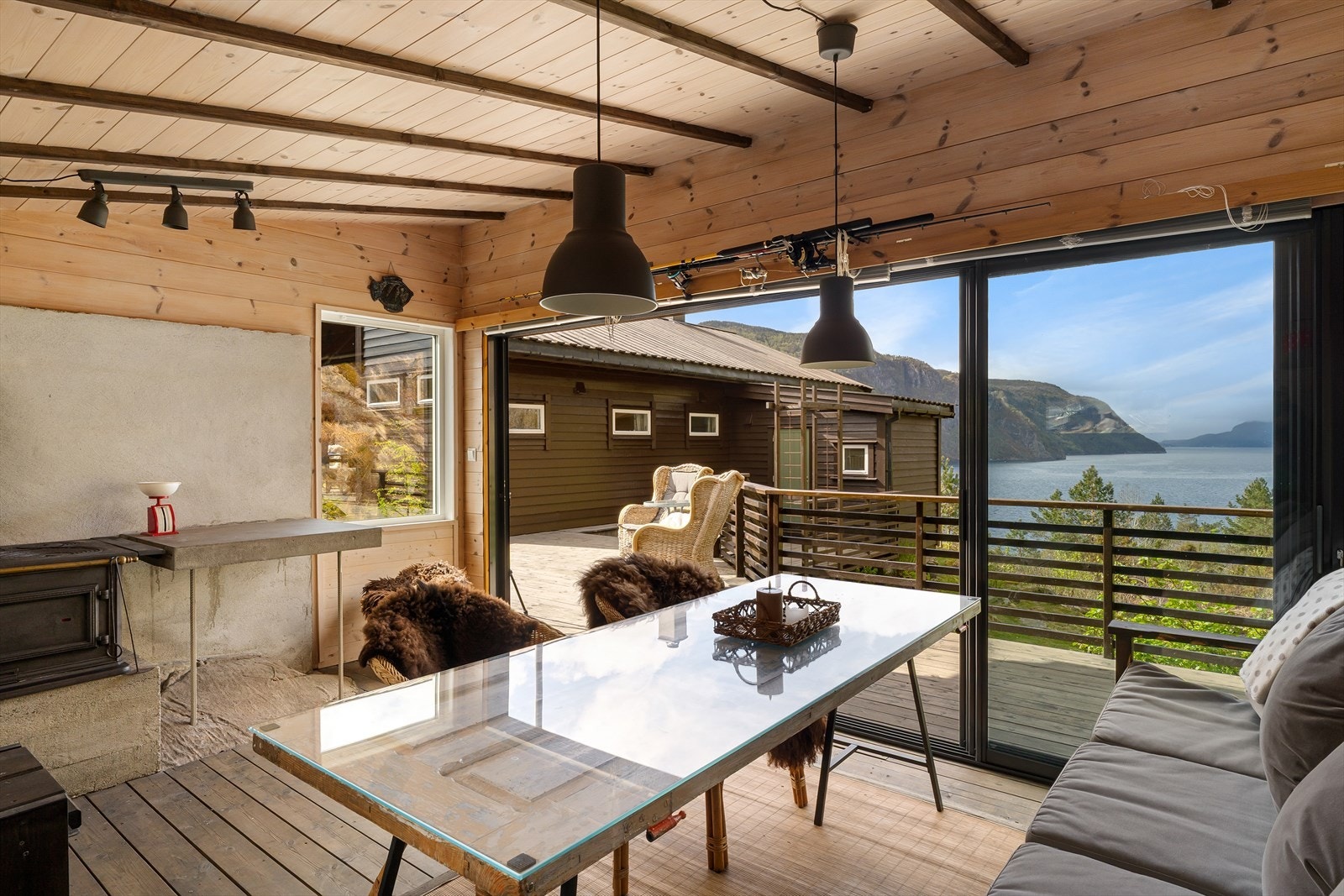Store skyvefelt i aluminium og glass åpner hagestuen helt opp mot terrassen og utsikten. Galleribilde