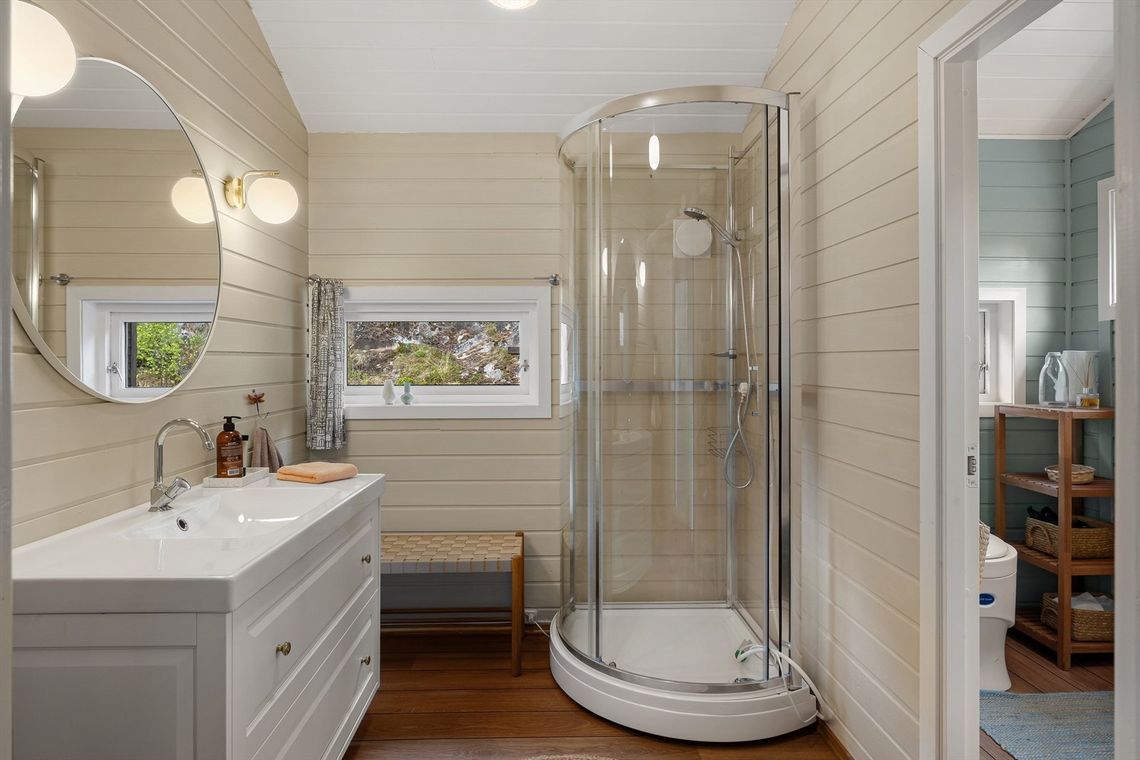 Badet har panel på veggene, laminat på gulvet og naturlig ventilering. Galleribilde