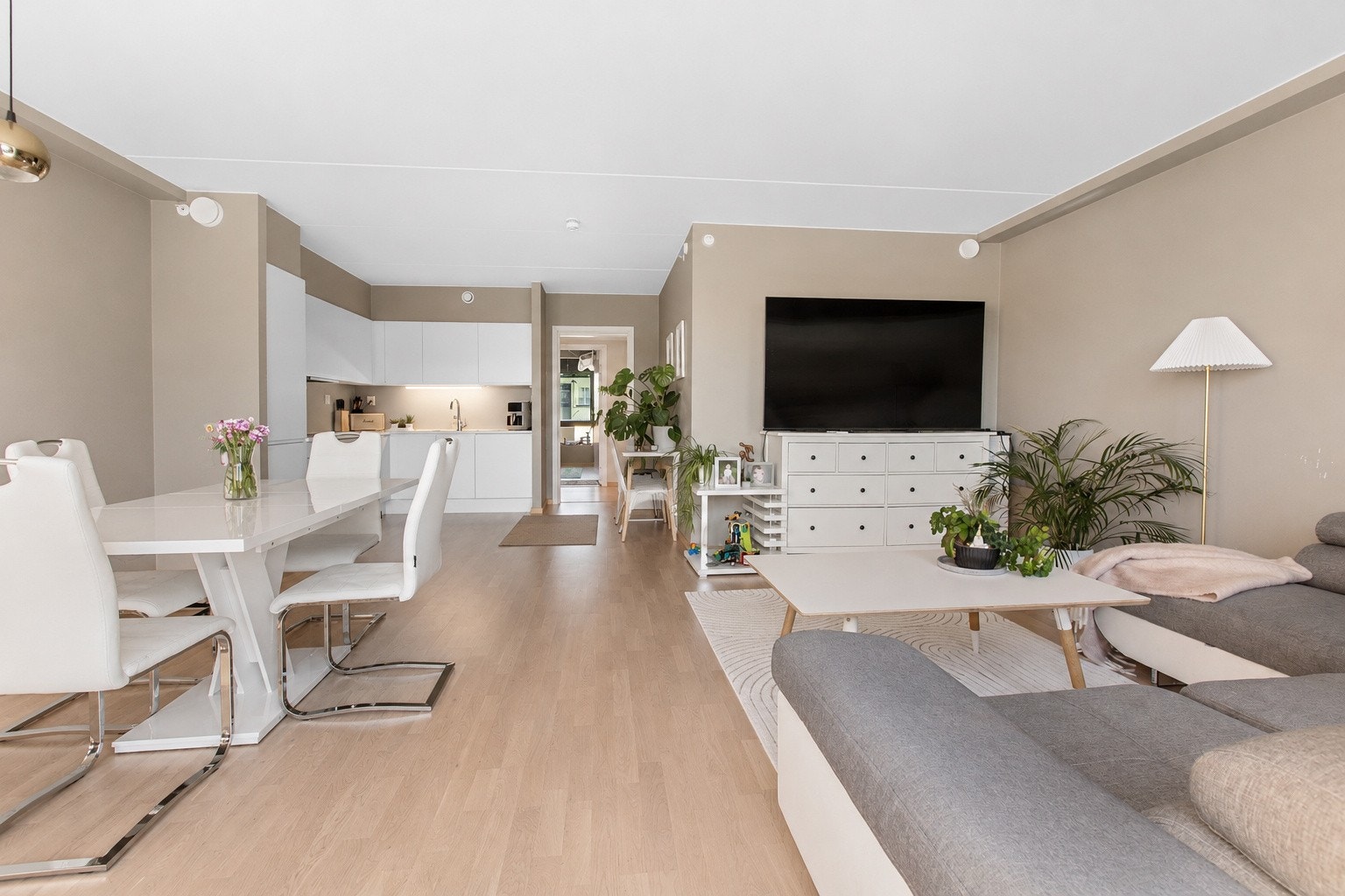 Stuen fremstår som lys, koselig og innbydende, med en stilren innredning som skaper en åpen og luftig atmosfære. Den åpne løsningen mot kjøkkenet gir en sosial og funksjonell planløsning. Galleribilde