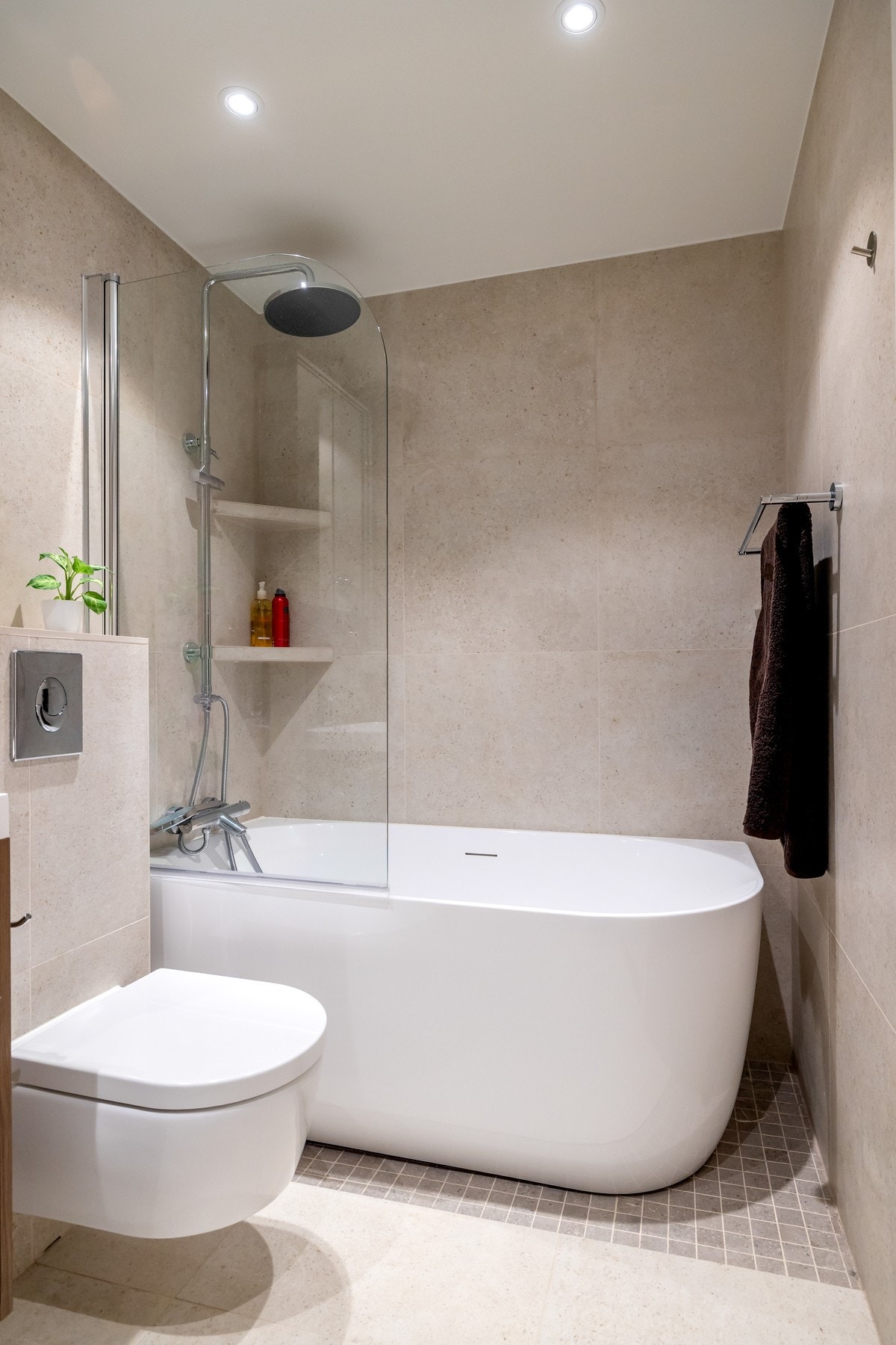 Badet har lyse, flislagte overflater, elektrisk gulvvarme og downlights Galleribilde