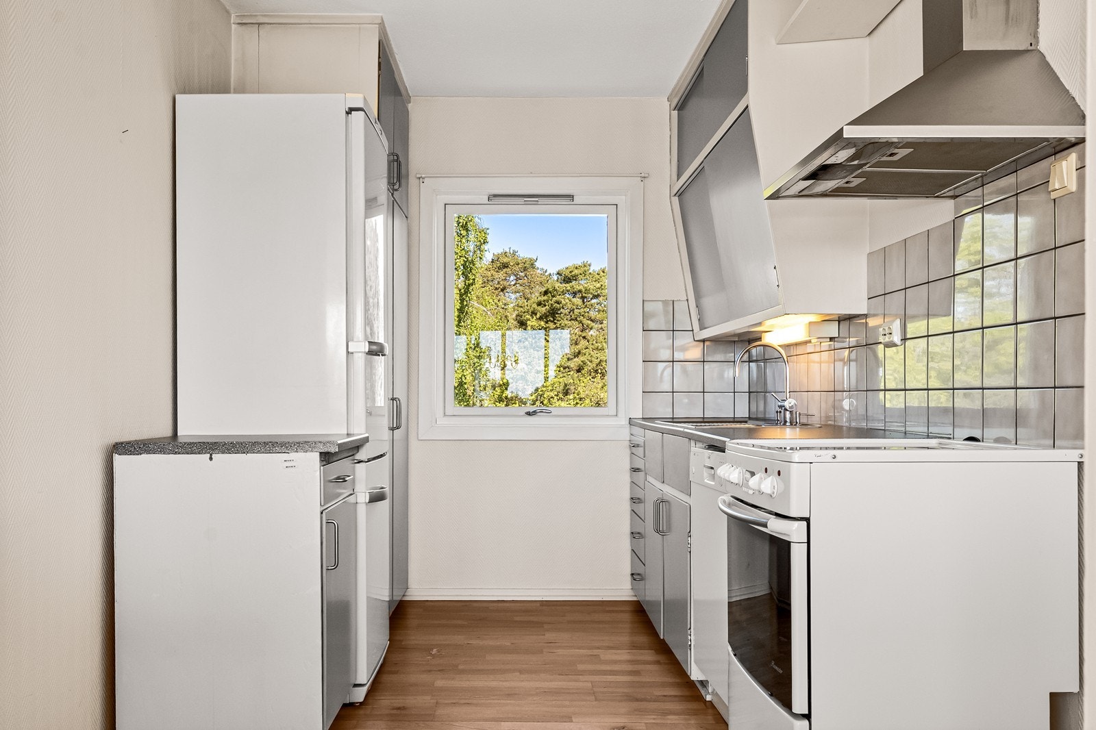 Kjøkkeninnredning med slette fronter og laminat benkeplate. Det er opplegg for oppvaskmaskin. Galleribilde