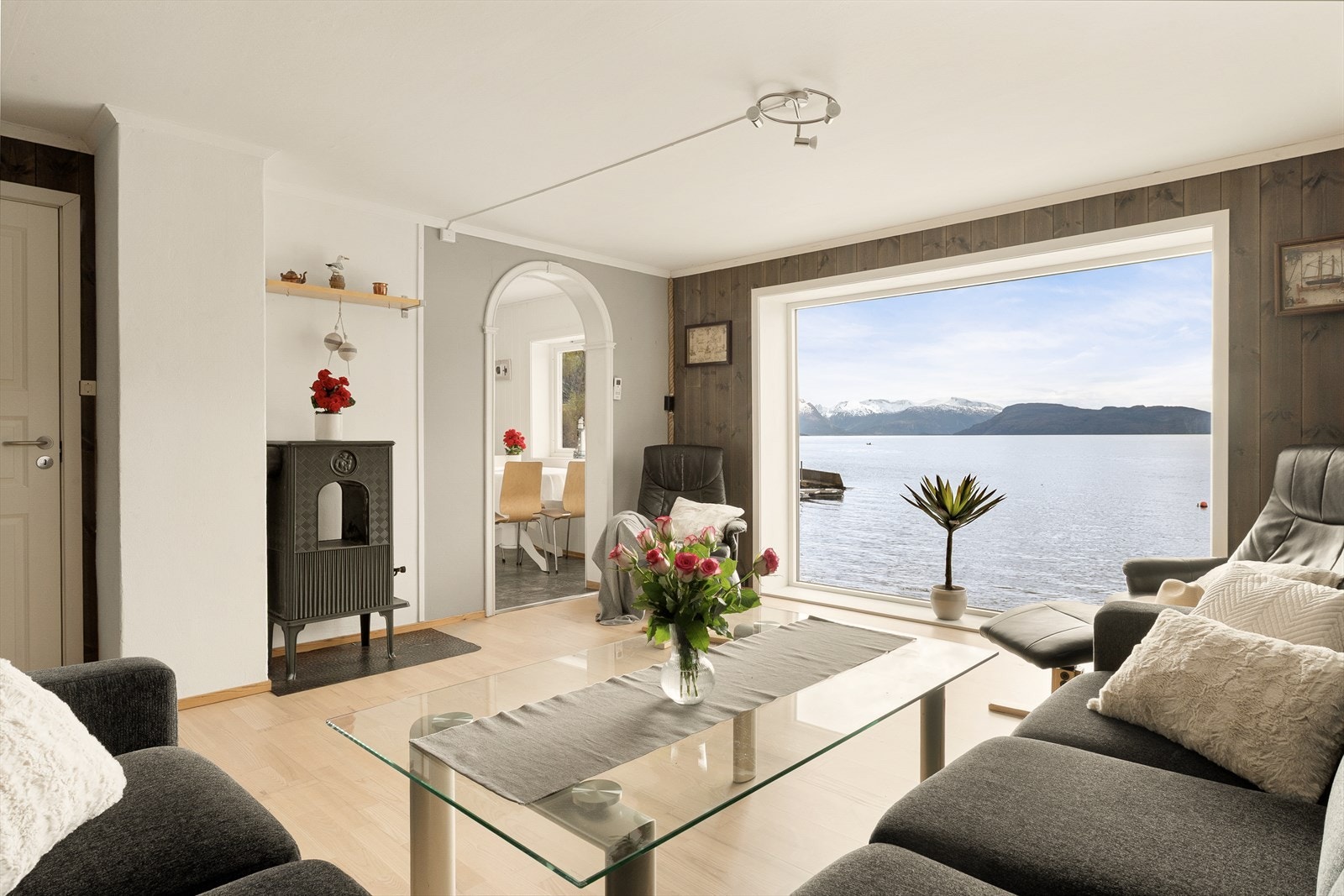 Lys og innbydende stue med store vindusflater som rammer inn den flotte utsikten mot fjorden. Galleribilde