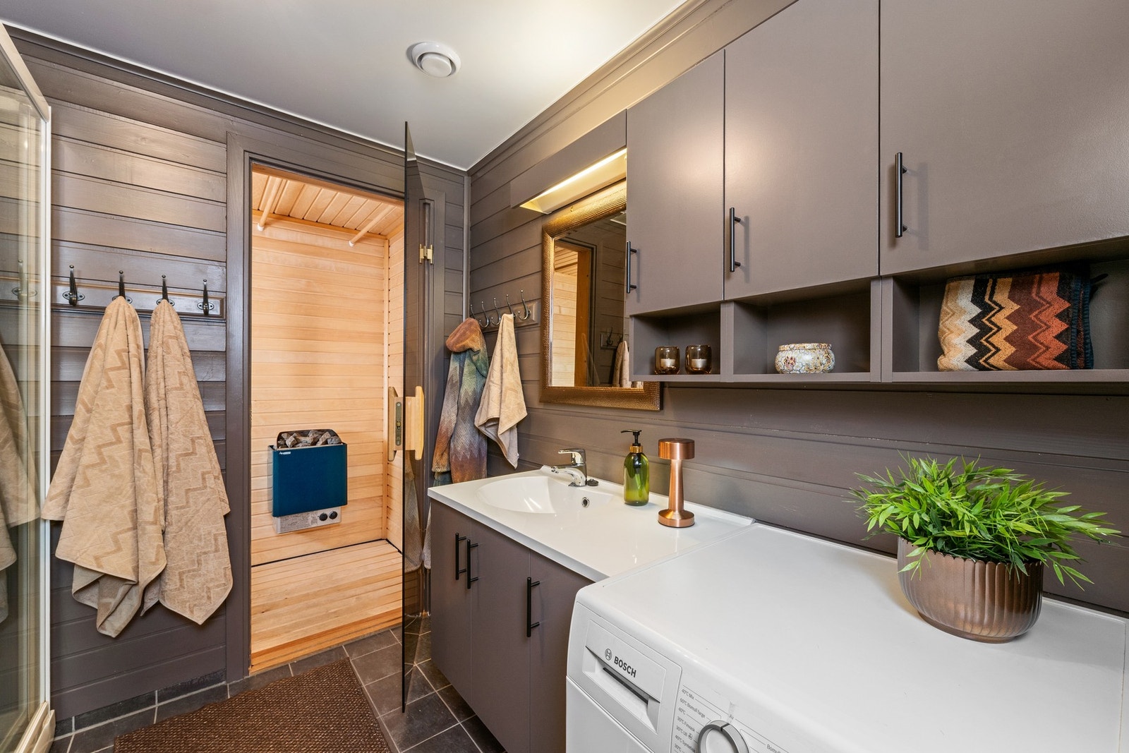 Badet er innredet med servant, toalett, dusj, badstue og opplegg for vaskemaskin. Galleribilde