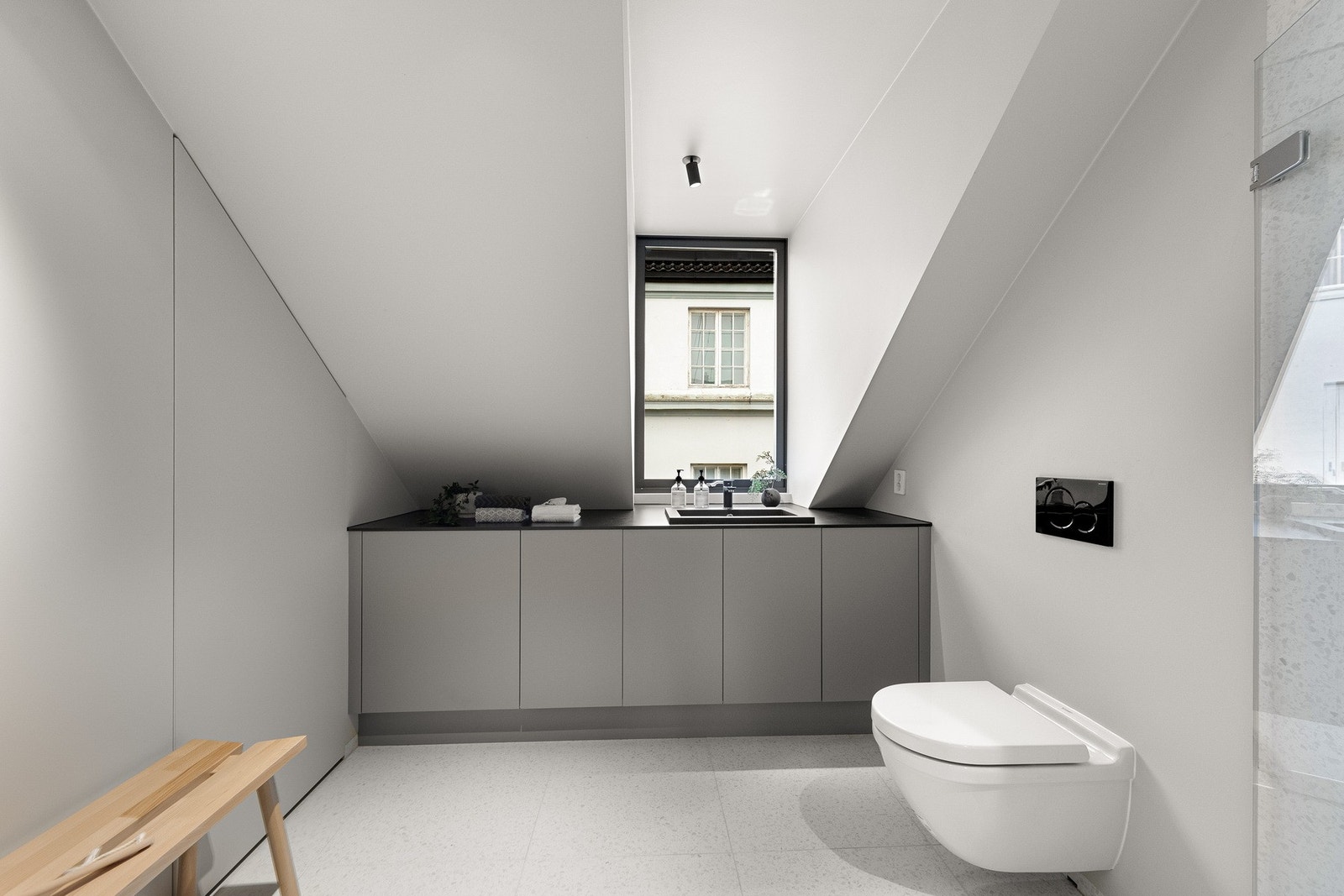 Badet er moderne med steinmønstret gulvfliser i størrelse 60x60 cm og vegger med en kombinasjon av fliser, plater og malte flater. Galleribilde