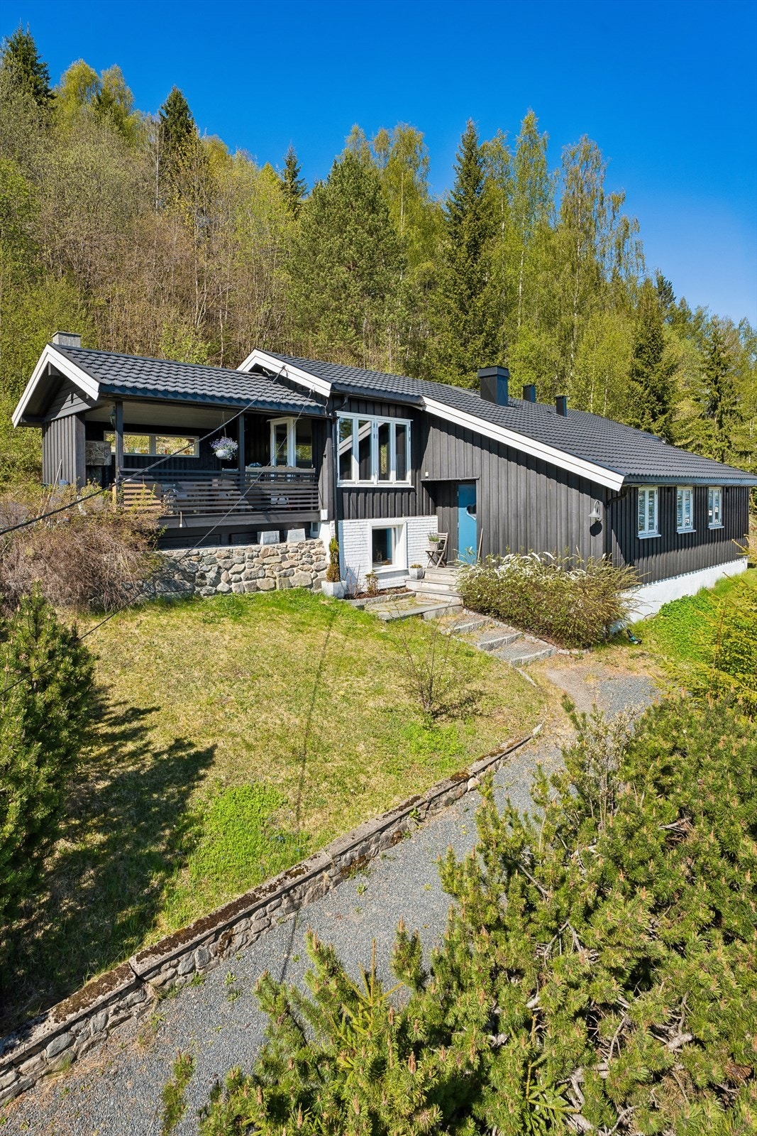 Eiendommen har en skrånende tomt opparbeidet med plen og beplantning, samt en egen garasje. Galleribilde