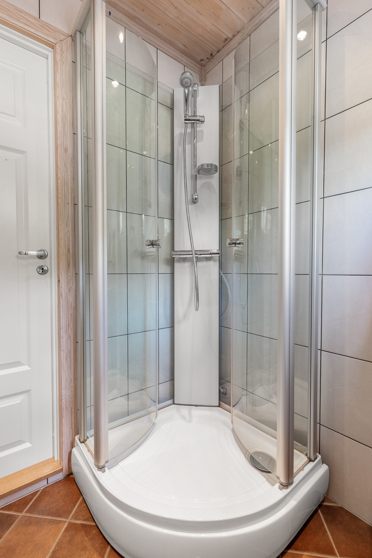 Badet er utstyrt med vegghengt servant med armatur, speil med overlys og dusjkabinett med dusjarmatur Galleribilde