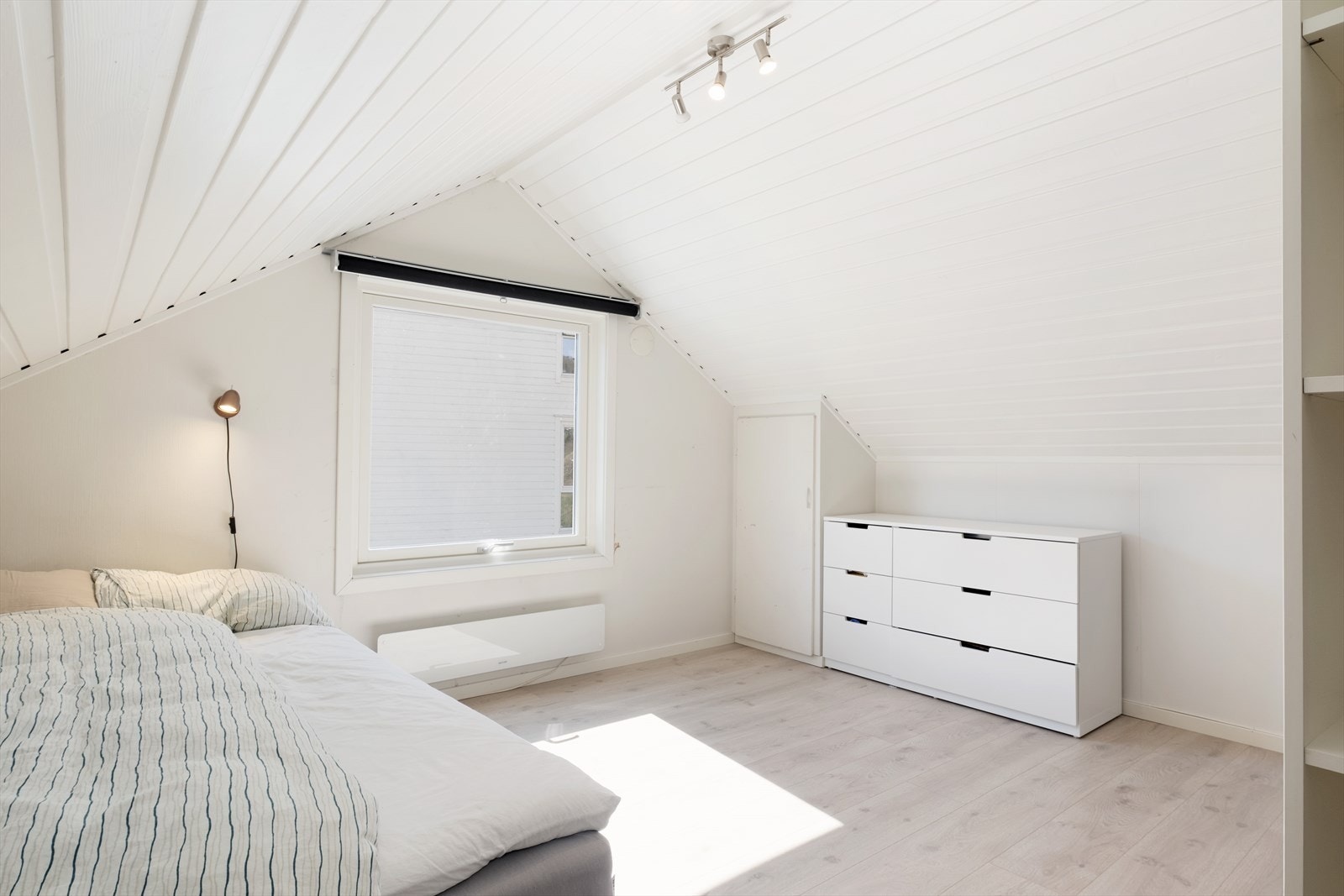 Innreidd rom på loftet med laminat på golvet og måla plater på vegg. Galleribilde