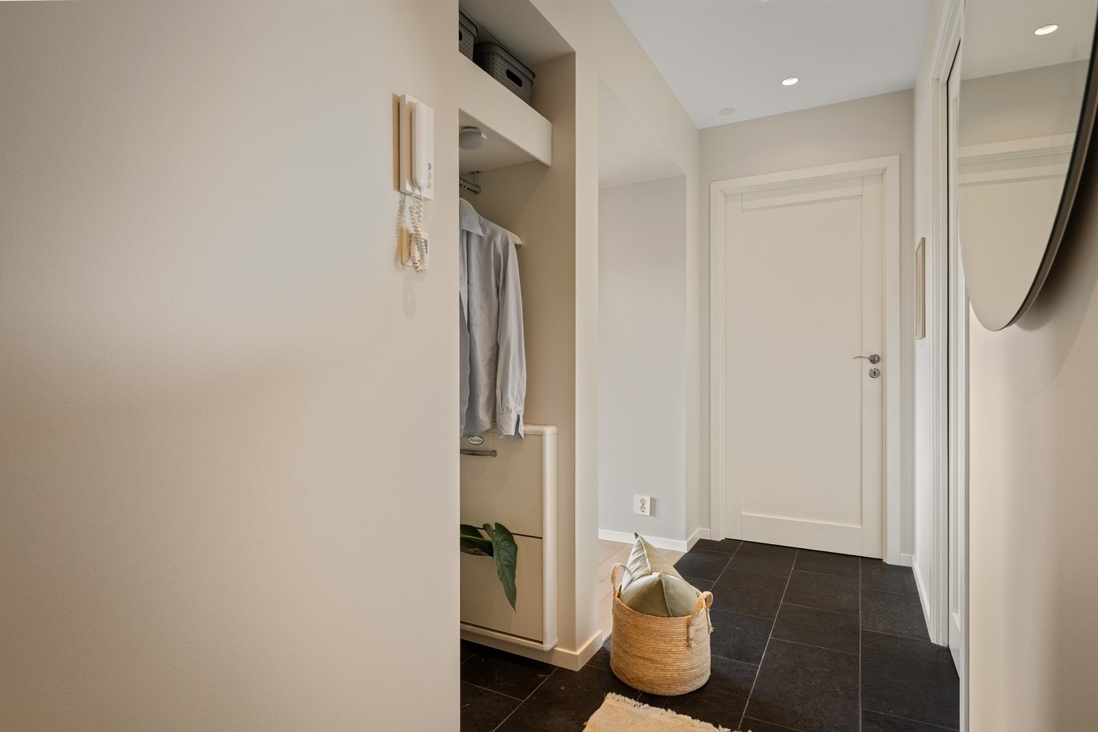 Det første man møter er en lys og innbydende entré/gang med skifer på gulv, downlights i tak og malte flater. Her er det mulighet til å henge fra seg yttertøy og sko. Porttelefon åpner opp for besøkende. Galleribilde