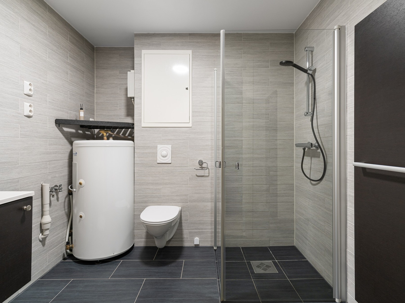 Badet har flislagt gulv og vegger, som gir et tidløst og moderne uttrykk. Rommet har vannbåren gulvvarme som sørger for behagelig komfort året rundt. Galleribilde