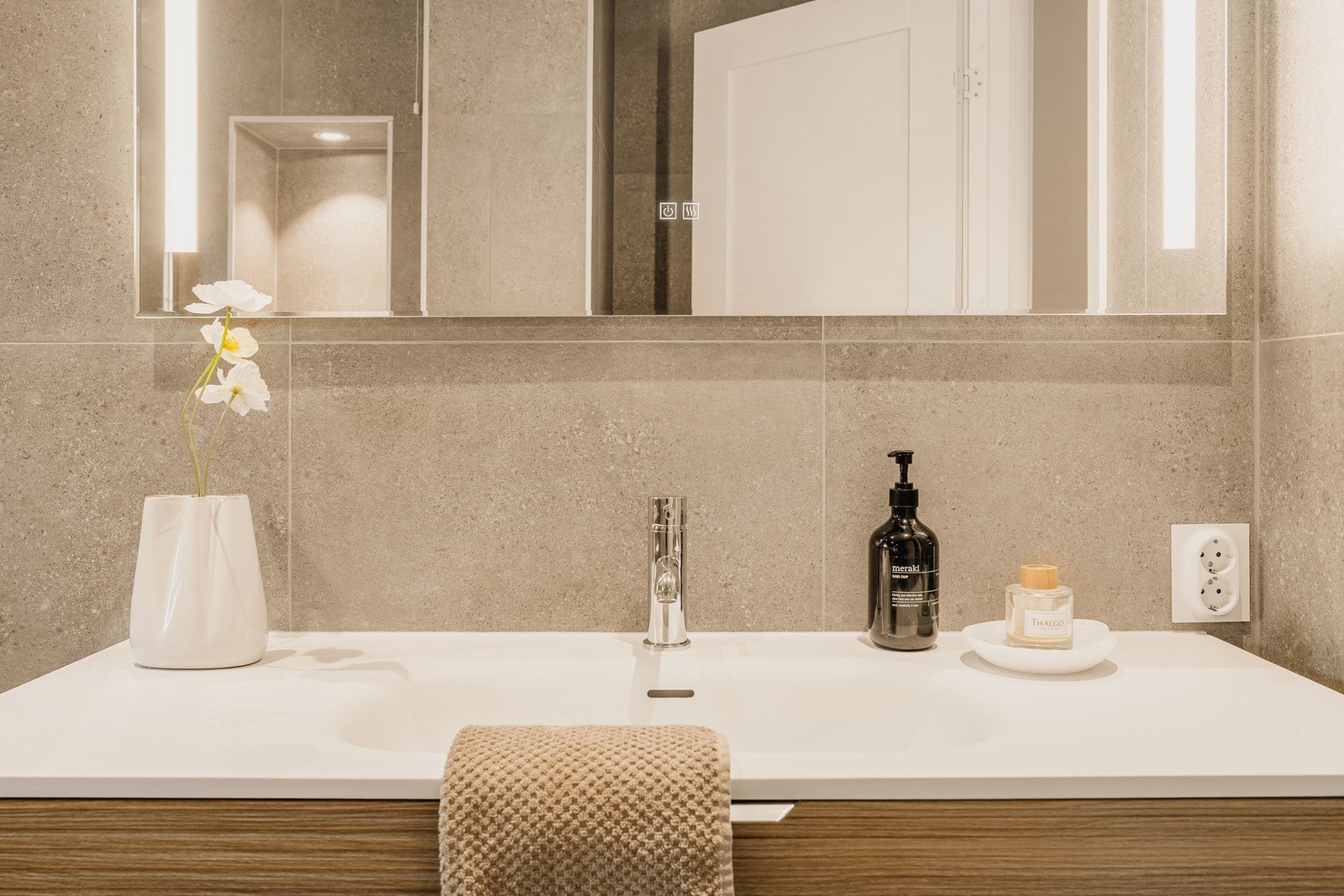 Badet er innredet med dusj med glassvegger, vegghengt toalett, baderomsinnredning, rør-i-rør system og opplegg for vaskemaskin. Galleribilde