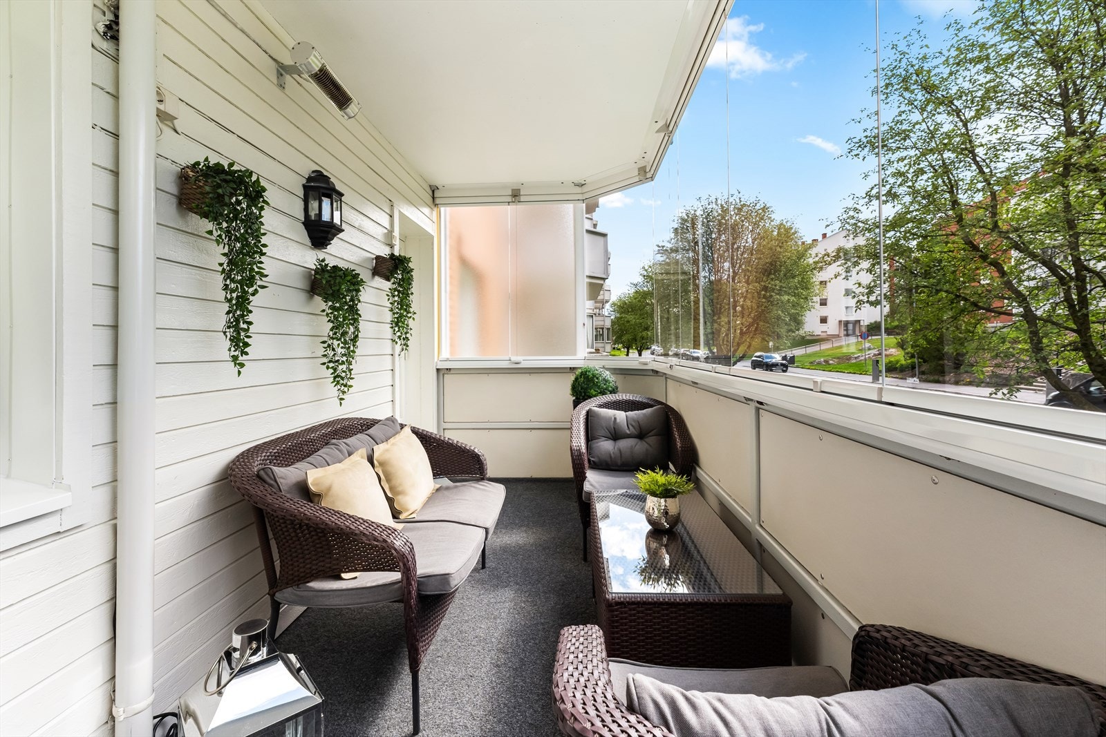 Innglasset balkong med hyggelig sittegruppe som skaper en komfortabel og skjermet uteplass - ideell for bruk hele året. Galleribilde