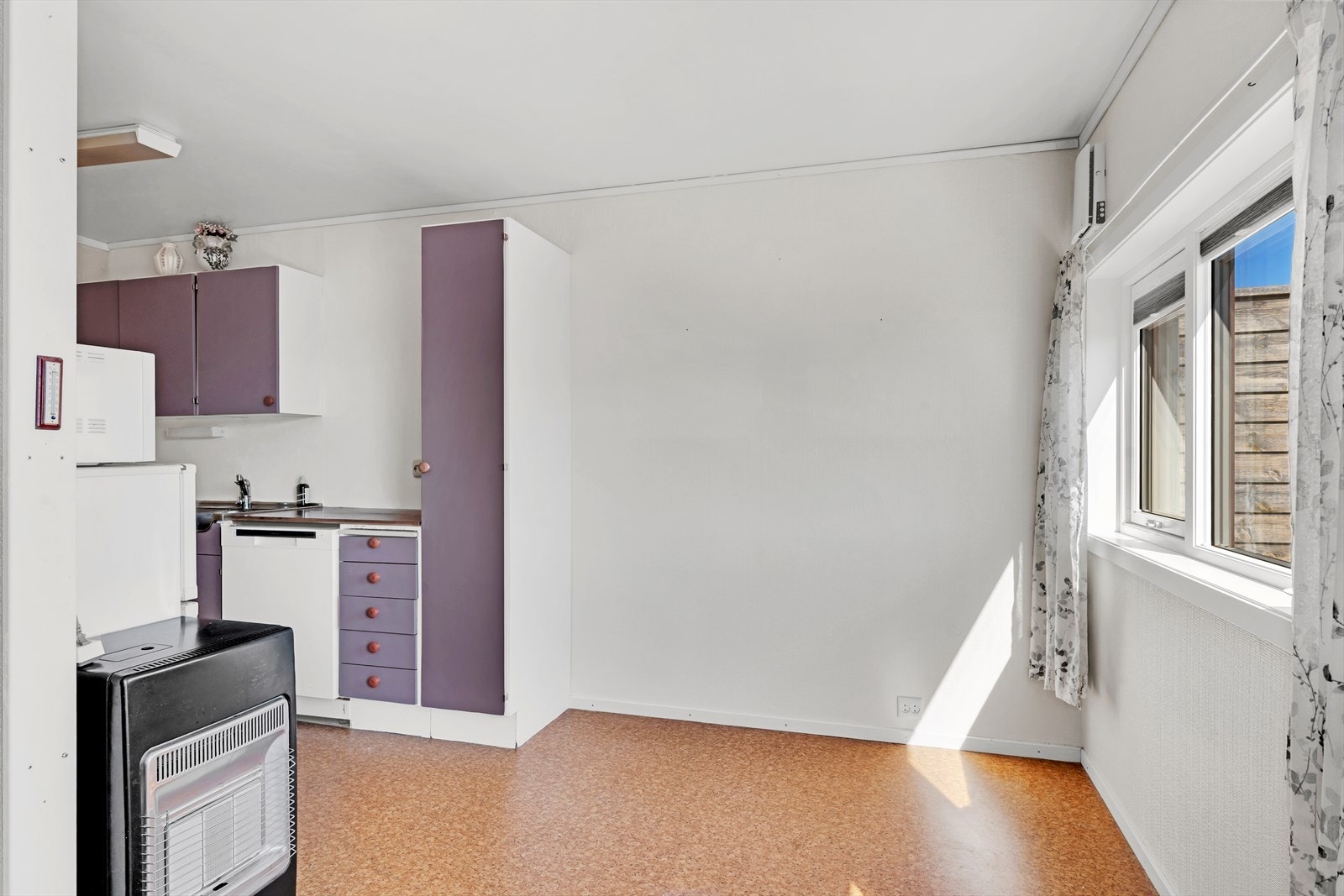 Kjøkkenet har glatte fronter og en benkeplate av laminat Galleribilde
