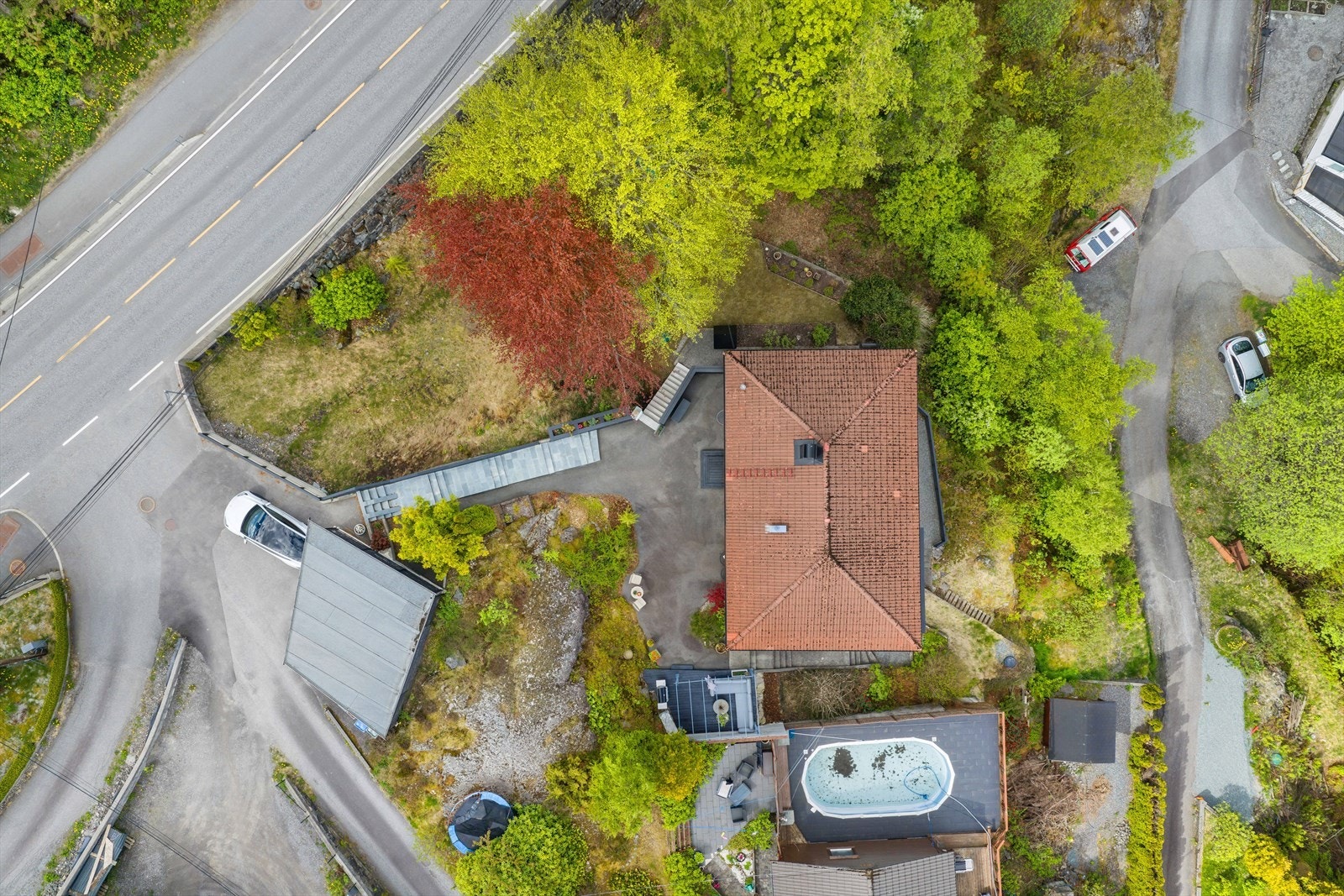 Oversikt over eiendommen med bolig, carport og uteområder. Galleribilde