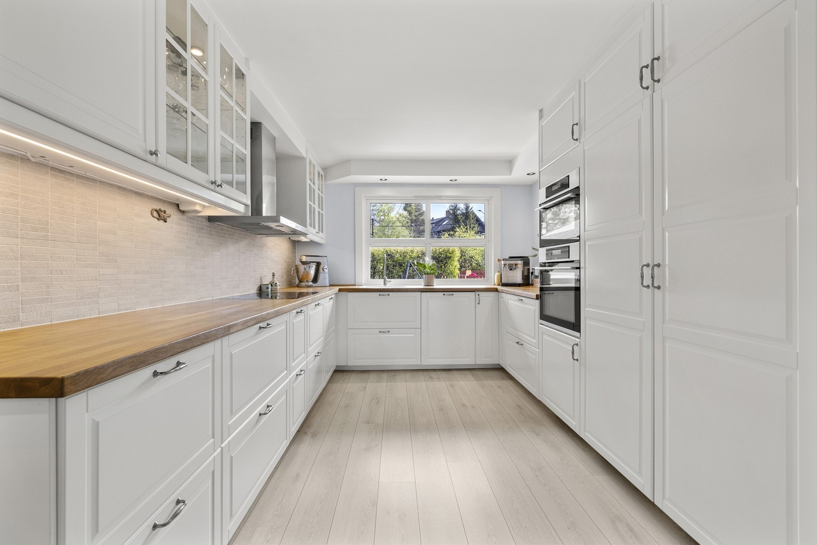 Kjøkkeninnredning med profilerte fronter og en solid benkeplate i heltre. Galleribilde