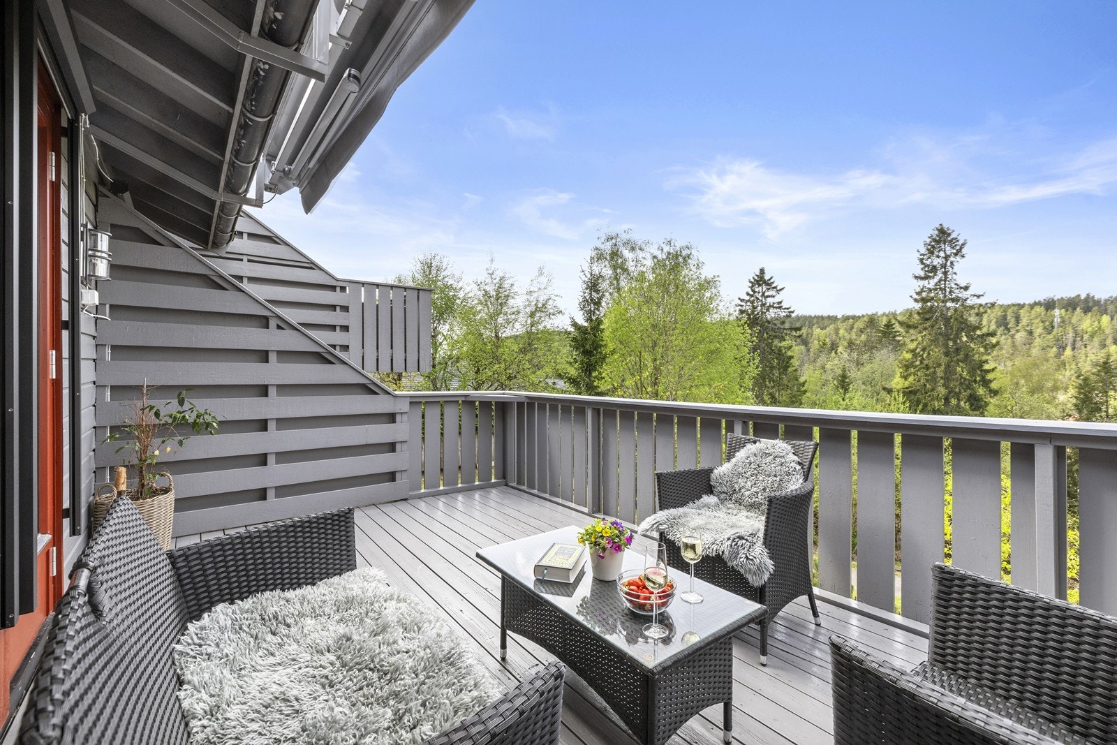 Romslig veranda med god plass til sittegruppe og utsikt mot grønne omgivelser. Galleribilde