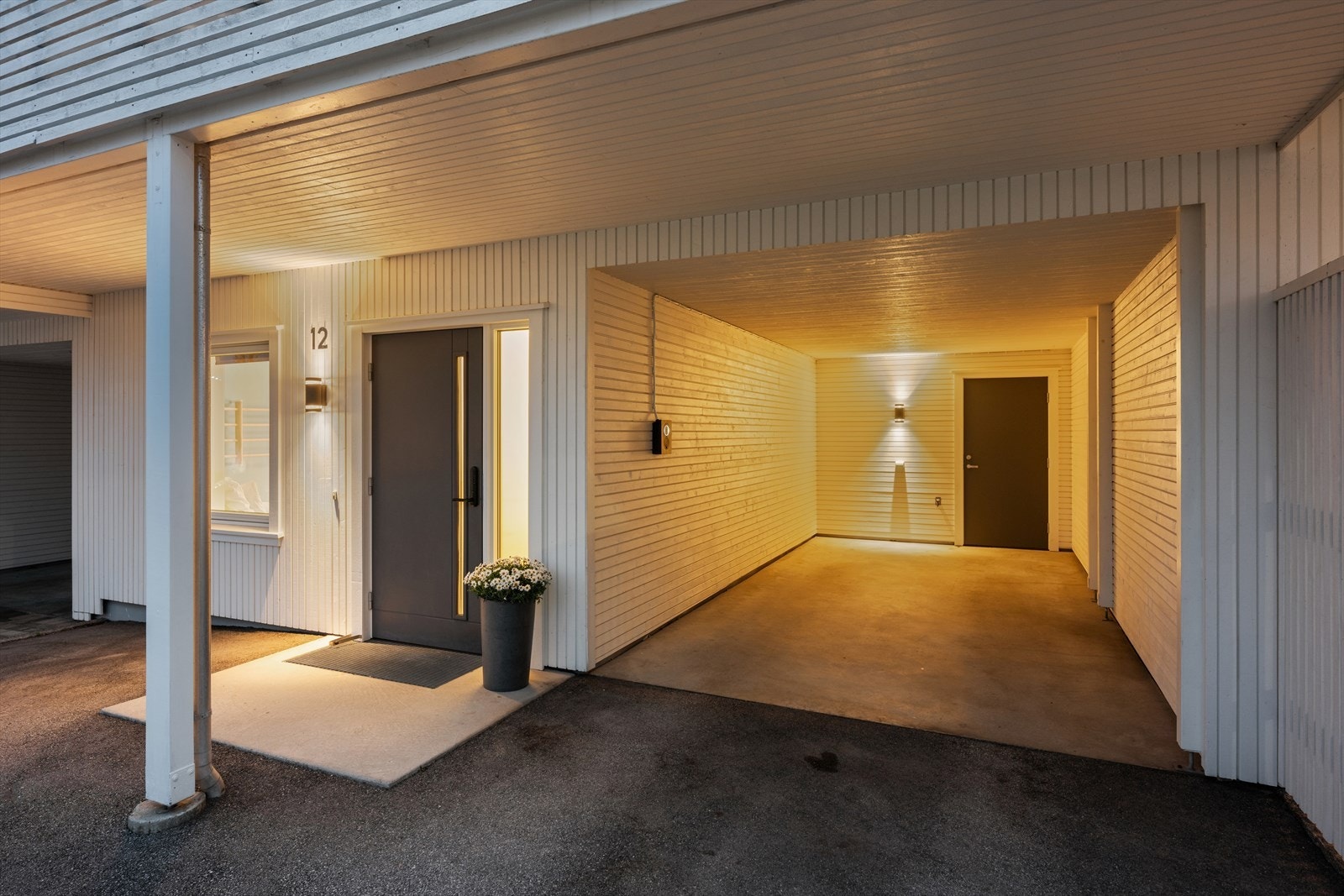 Parkering i integrert carport. Herfra er det også inngang til en praktisk, ekstern bod samt gjennomgang til terrasse/hage. Galleribilde