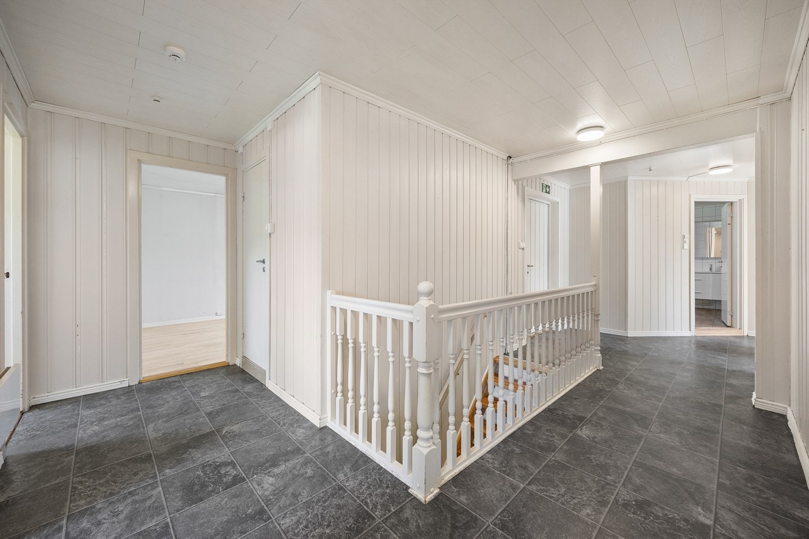 Gangen har malt tretrapp med lakkerte trinn ned til kjelleretasjen. Galleribilde