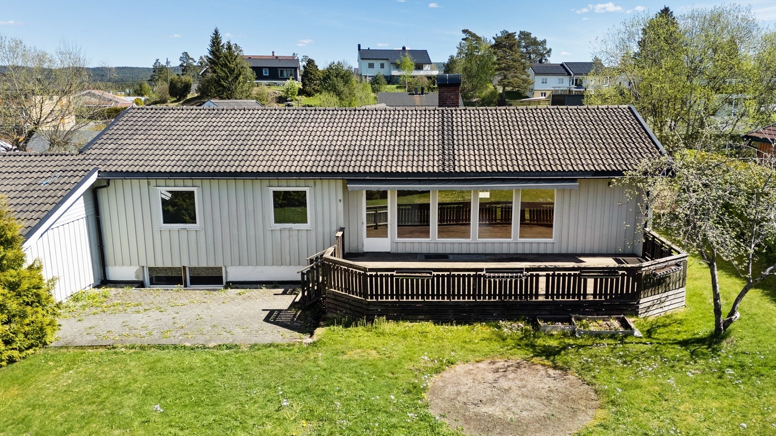 Eneboligen har en fasade med stående bordkledning og tak tekket med betongtakstein. Galleribilde