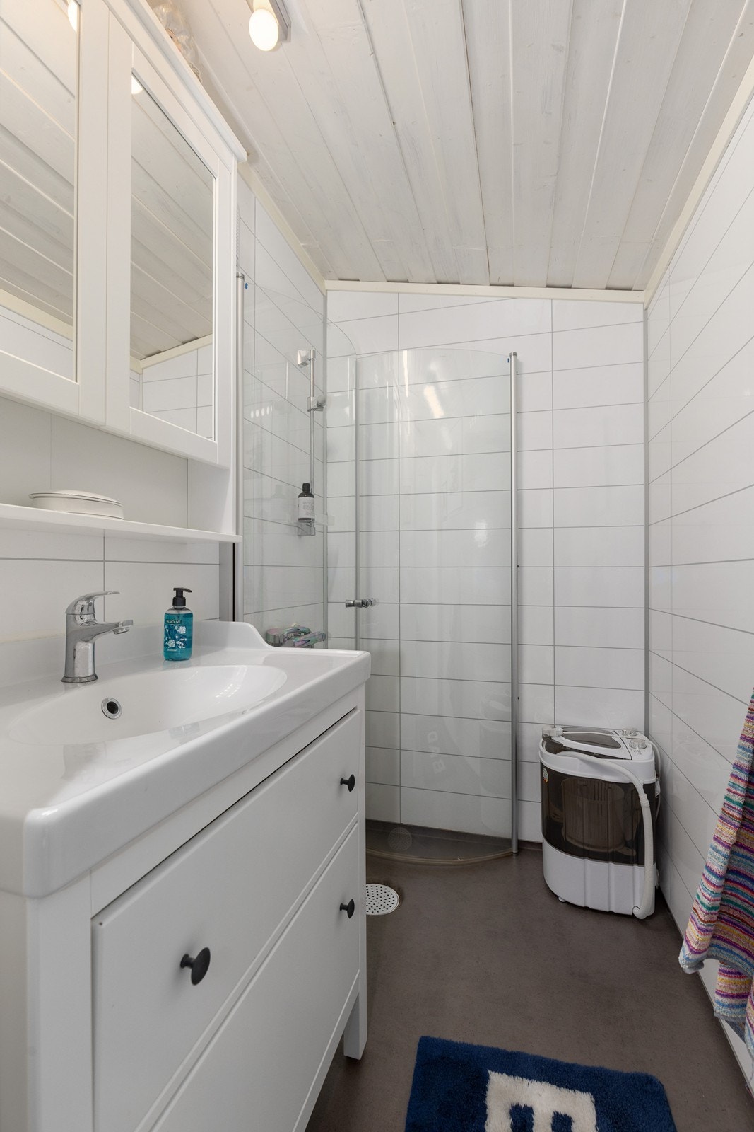 Badet fremstår moderne og funksjonelt, med dusjløsning, servantinnredning og oppbevaringsplass. Galleribilde