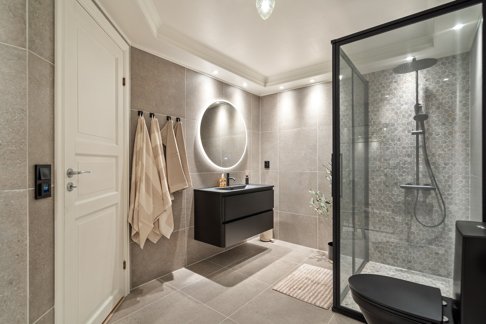 Badet fremstår svært gjennomført med romslig dusjløsning, elegant innredning og en lun spa-følelse. Galleribilde