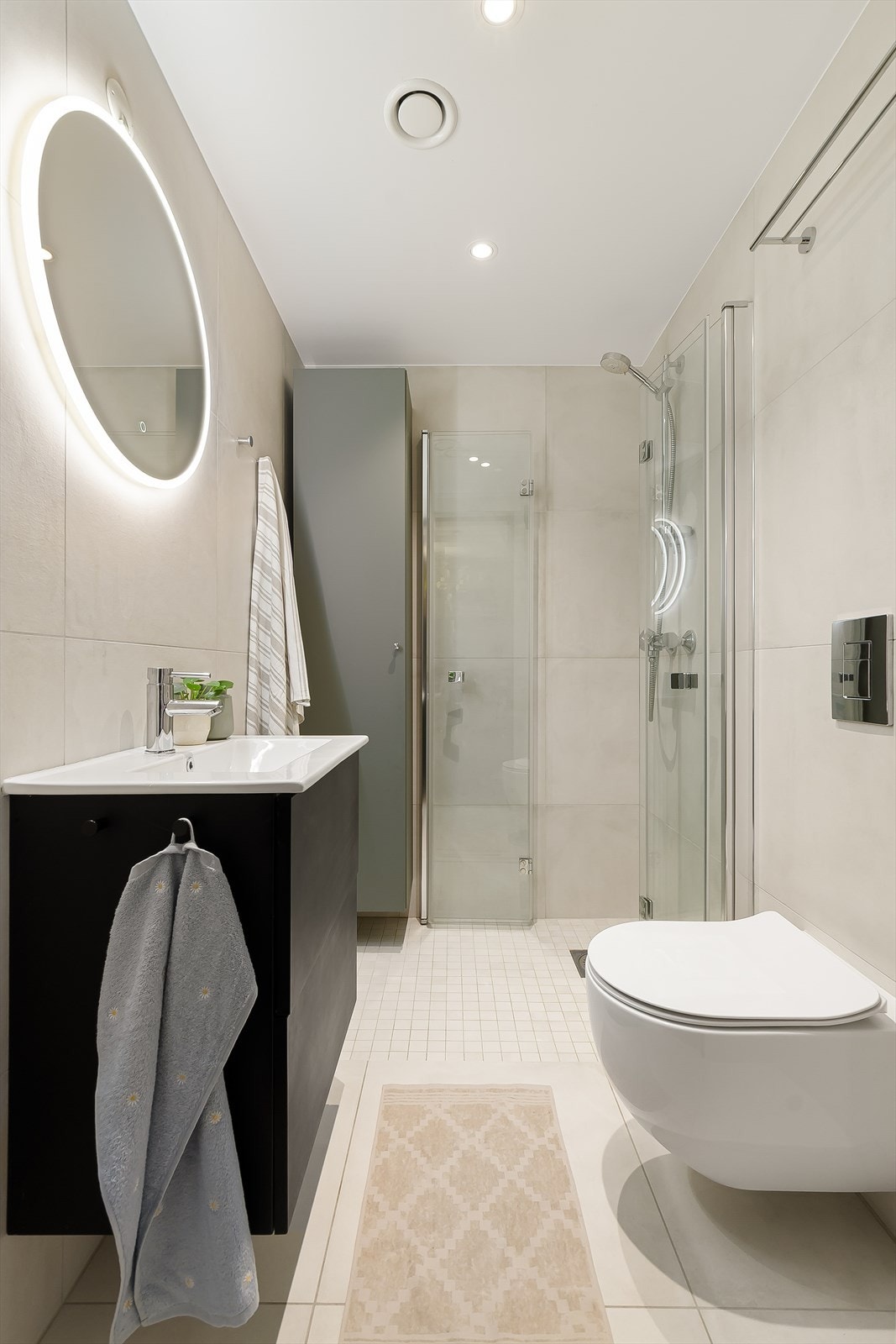 Badet holder en gjennomgående høy standard og er innredet med servant med skuffer og speil, vegghengt toalett samt nedsenket dusj med glassdører. Galleribilde