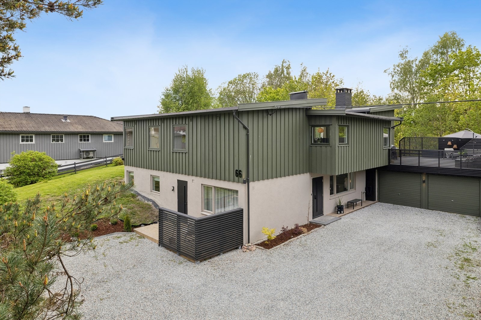 Stor gruset gårdsplass og dobbeltgarasje. Galleribilde