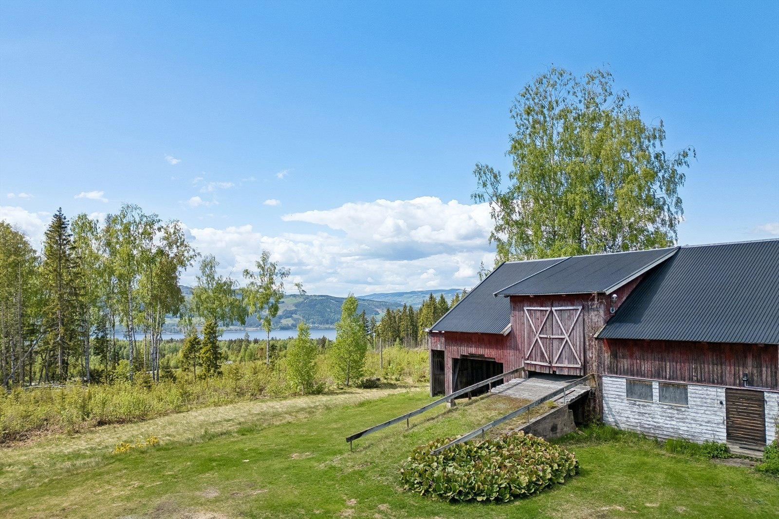 Låvebygningen har tradisjonell utførelse med trekledning og metallplater på taket, og bidrar til den landlige gårdstunfølelsen. Galleribilde