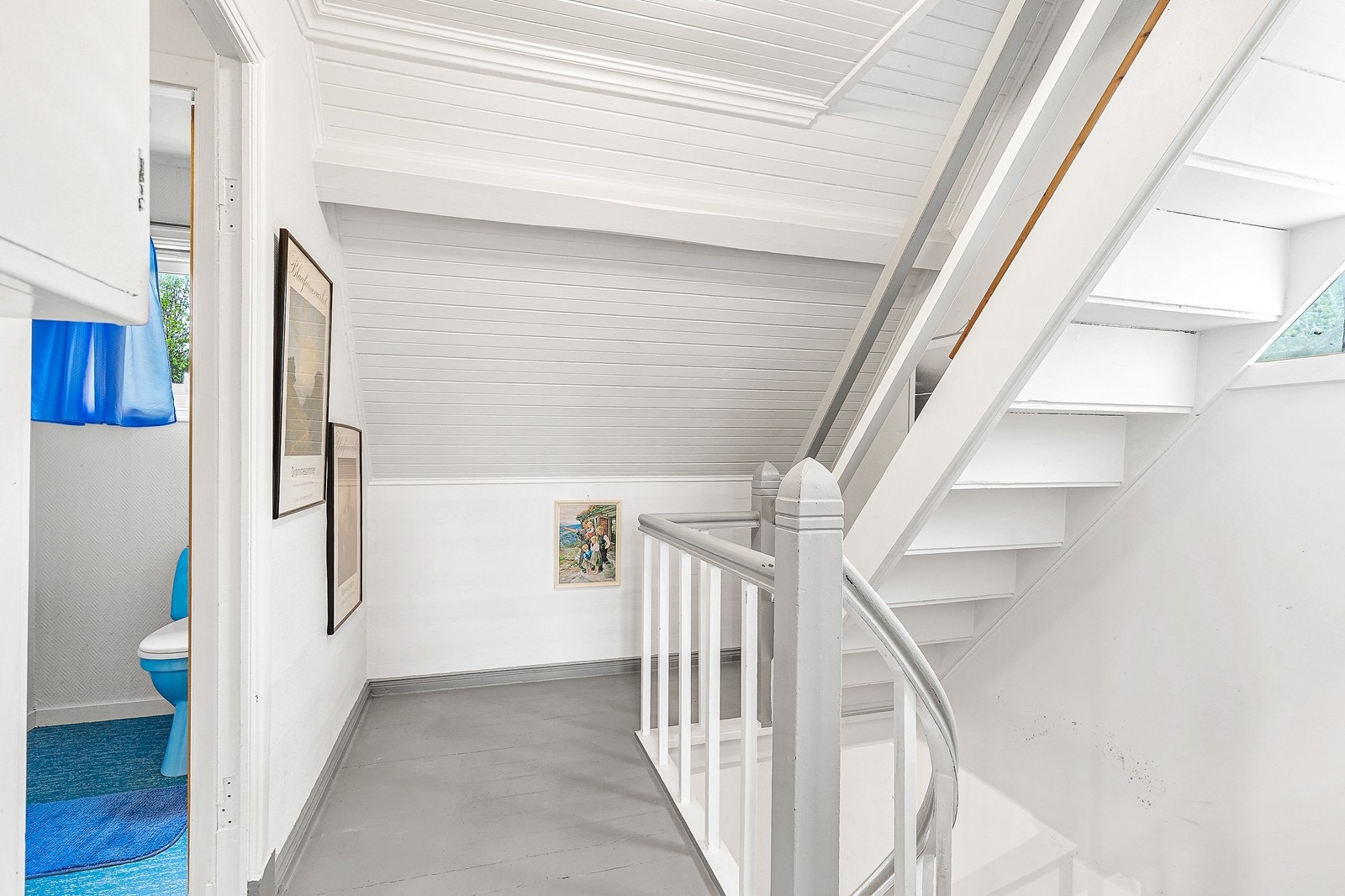 Hvitmalte overflater og trapp gir et lyst og praktisk rom mellom etasjene. Galleribilde