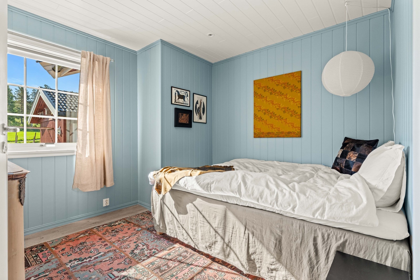 Et av boligens soverom, med vegger kledd i trepanel. Galleribilde