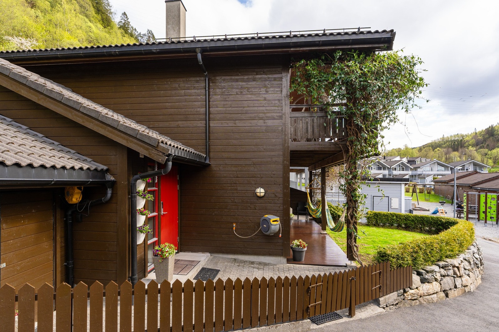 Eiendommen er pent rammet inn med beplantning, steinmur og gjerde. Galleribilde
