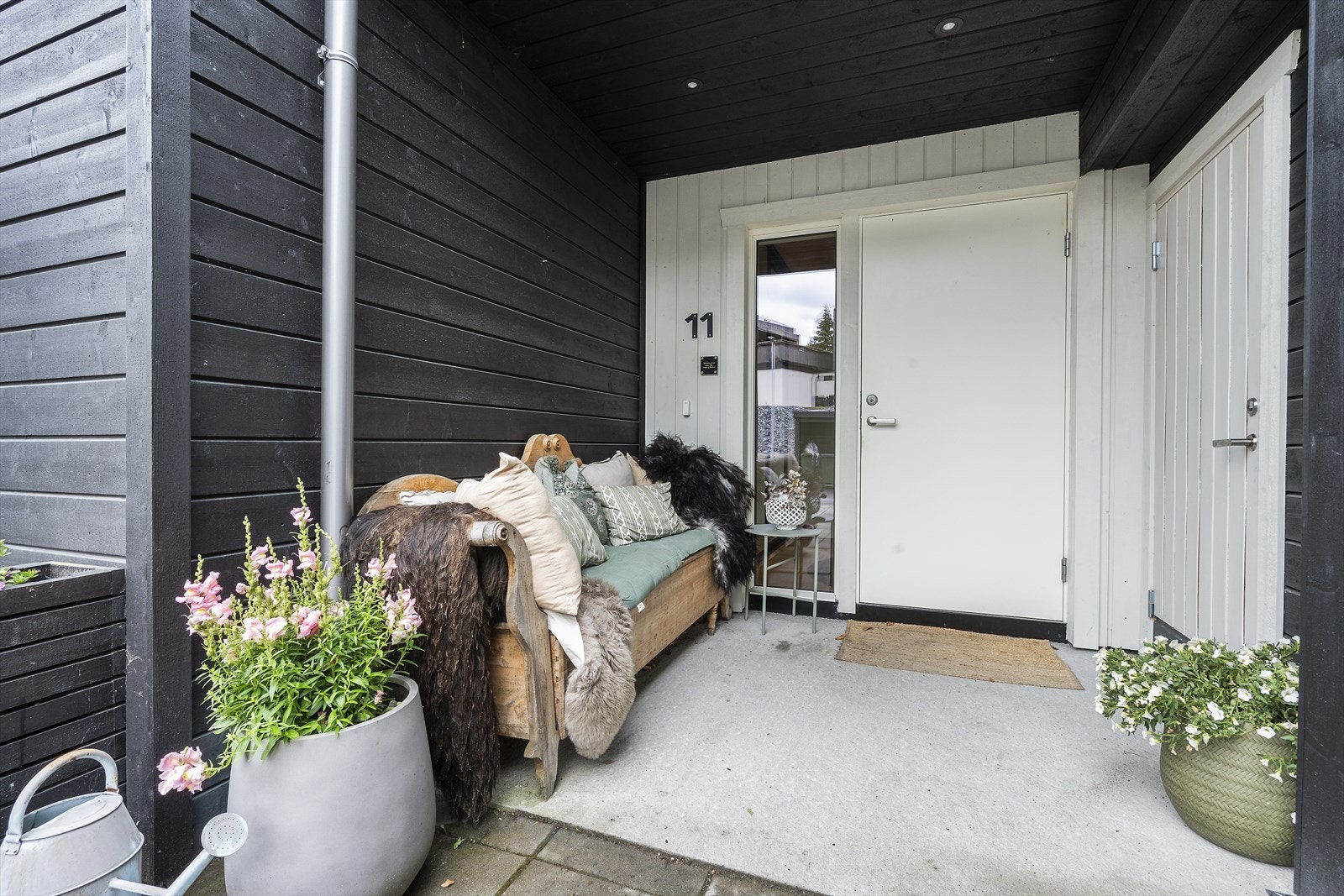 Praktisk overbygget inngangsparti gir skjerming for snø og regn og adkomst til romslig utvendig bod bak carport Galleribilde