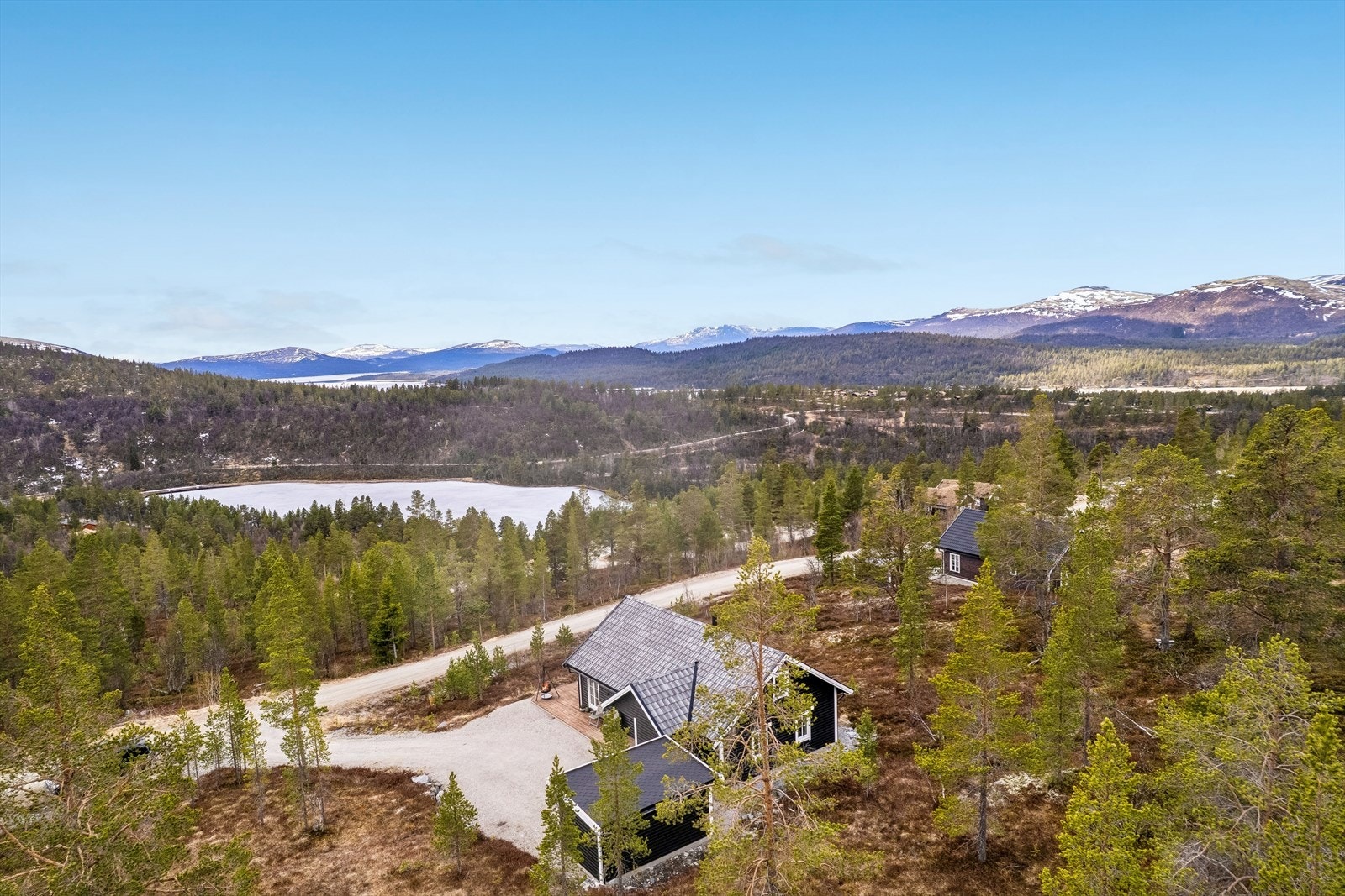 Fritidseiendommen ligger i et område med spredt hyttebebyggelse og naturtomt. Galleribilde